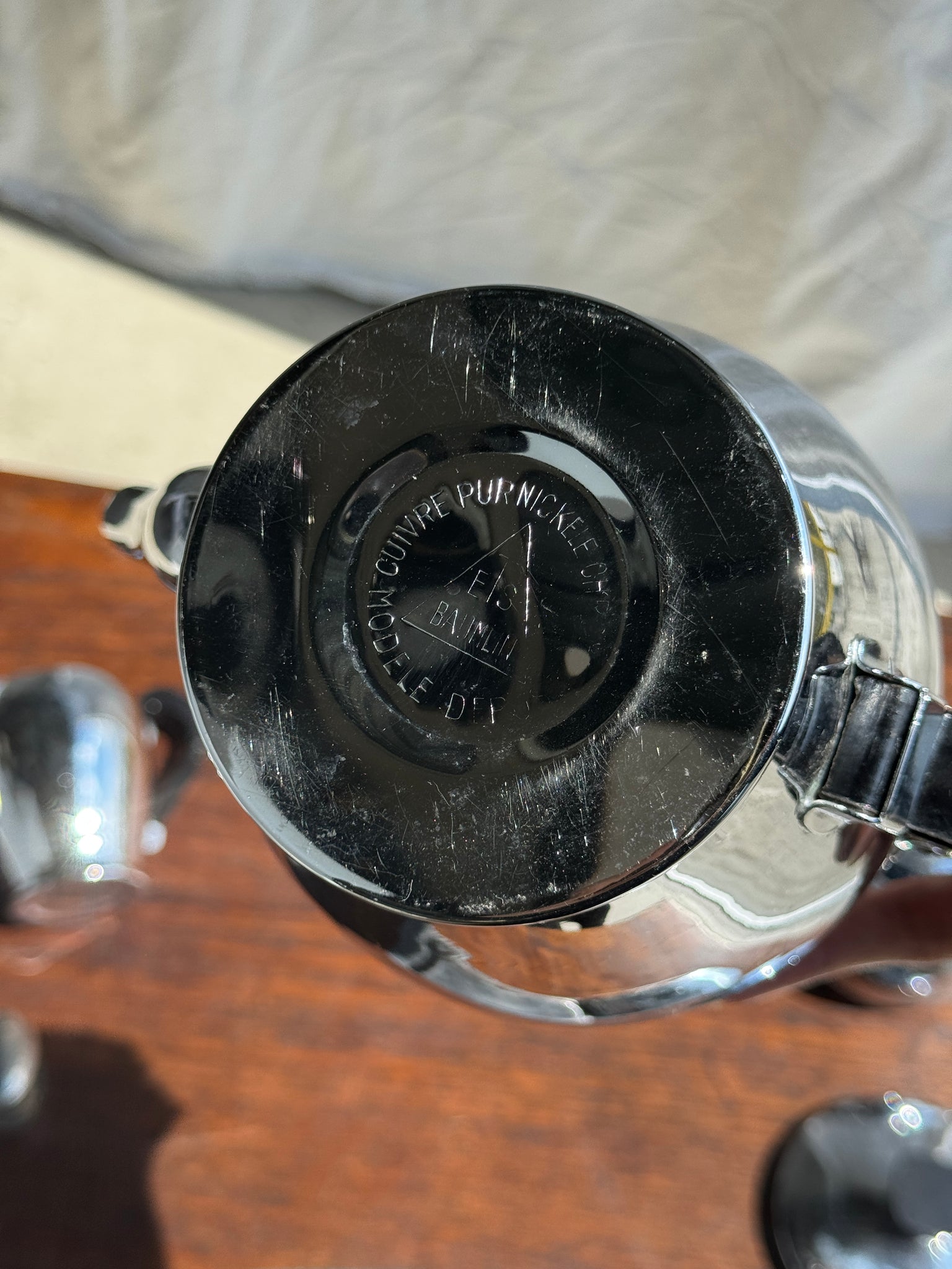 Service à thé comprenant une théière, un pot à lait, un sucrier et un beurrier en métal argenté et poignées noires