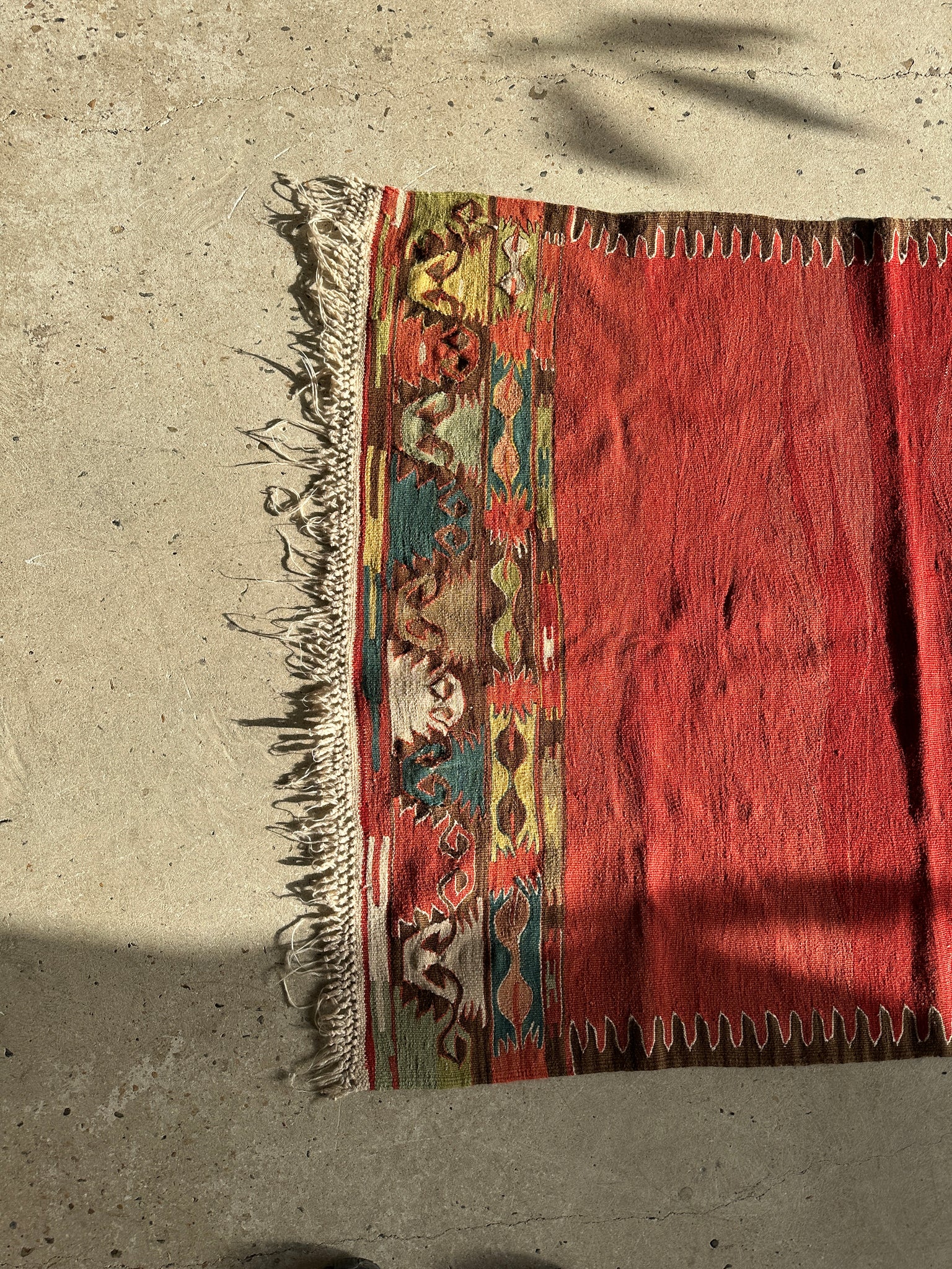Petit tapis en laine à dominante rouge avec motifs géométriques