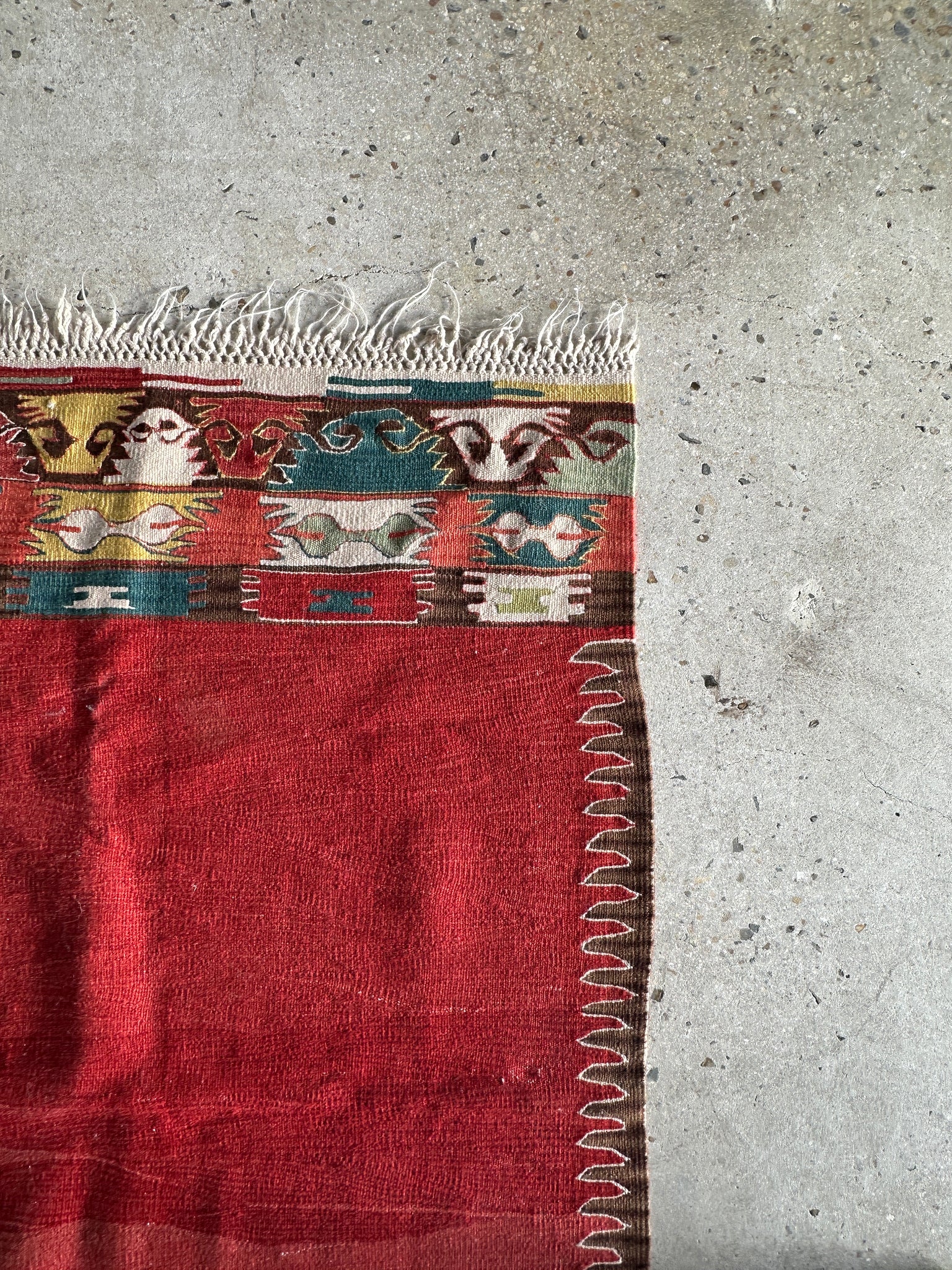 Petit tapis en laine à dominante rouge avec motifs géométriques