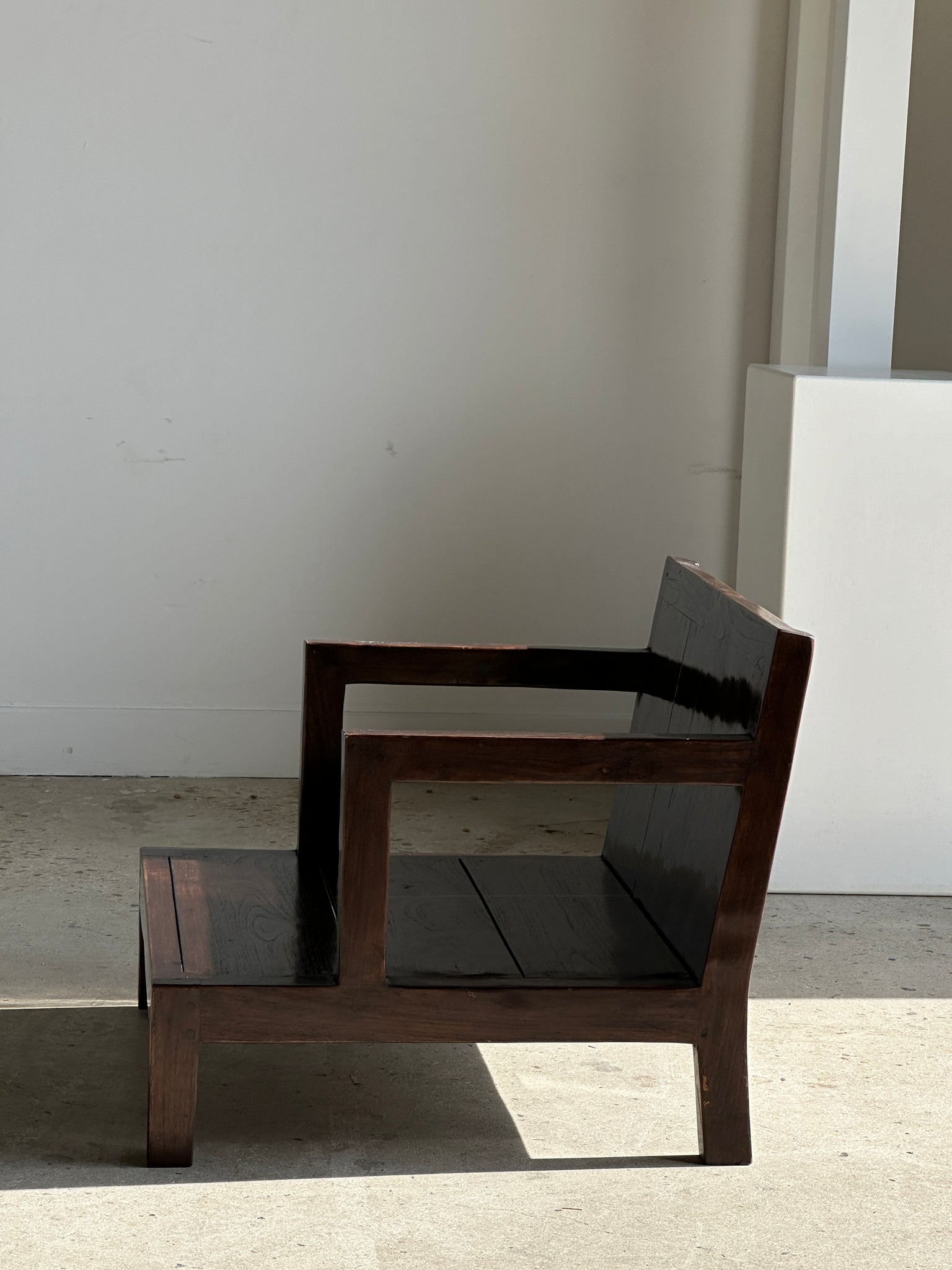 Petit fauteuil bas en bois brun verni