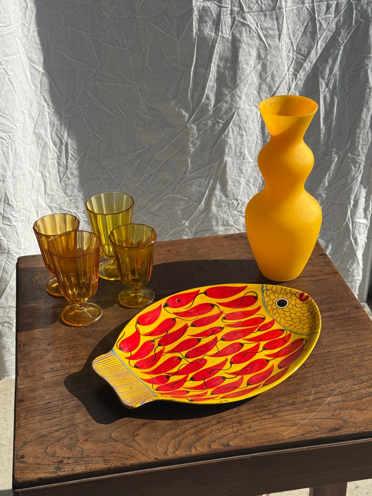 Plat décoratif en forme de poisson fond jaune à décor de piments rouges