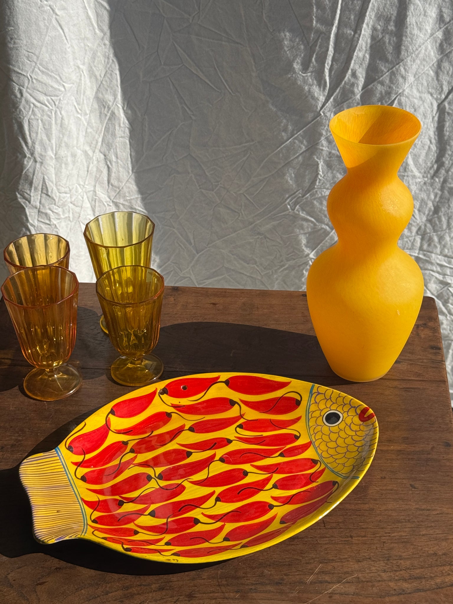 Plat décoratif en forme de poisson fond jaune à décor de piments rouges