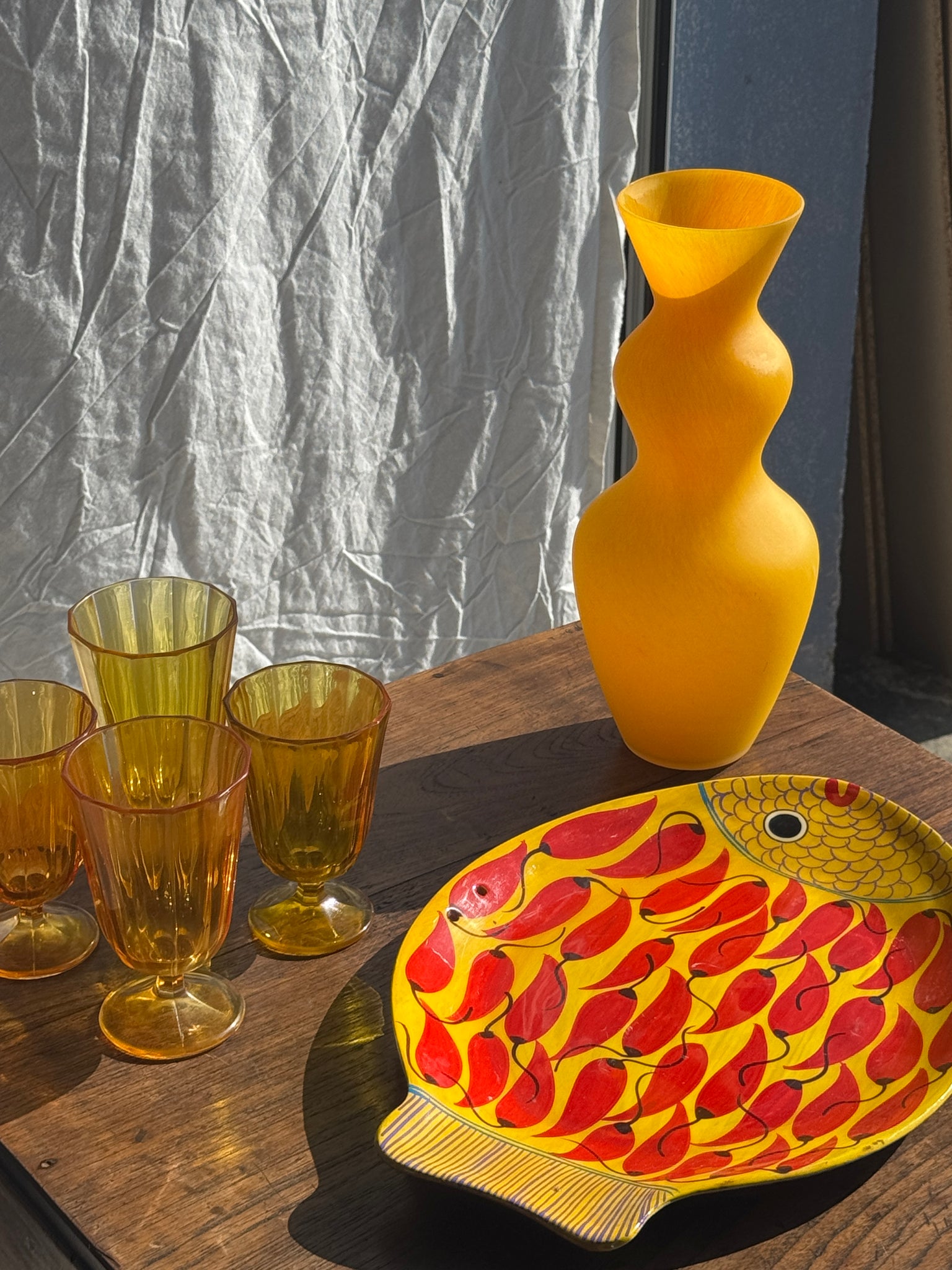 Plat décoratif en forme de poisson fond jaune à décor de piments rouges