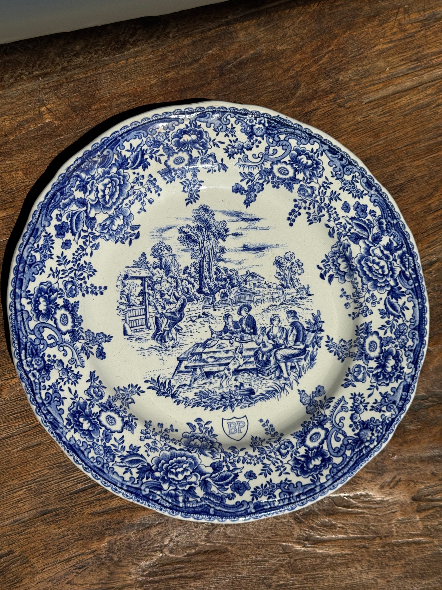 Une assiette à décor bleu en faïence BP à motif de fêtes villageoises