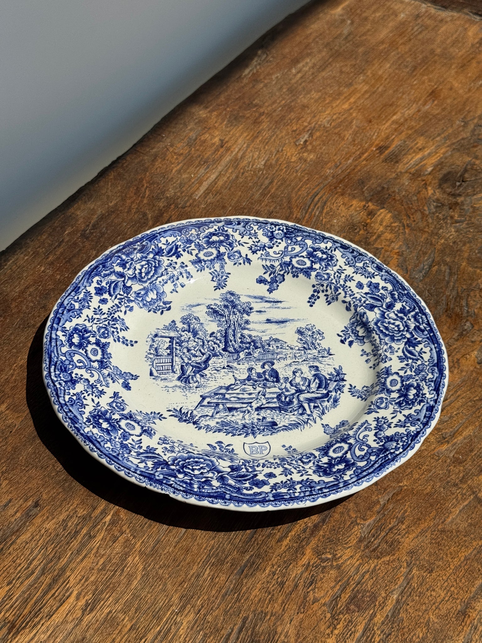 Une assiette à décor bleu en faïence BP à motif de fêtes villageoises