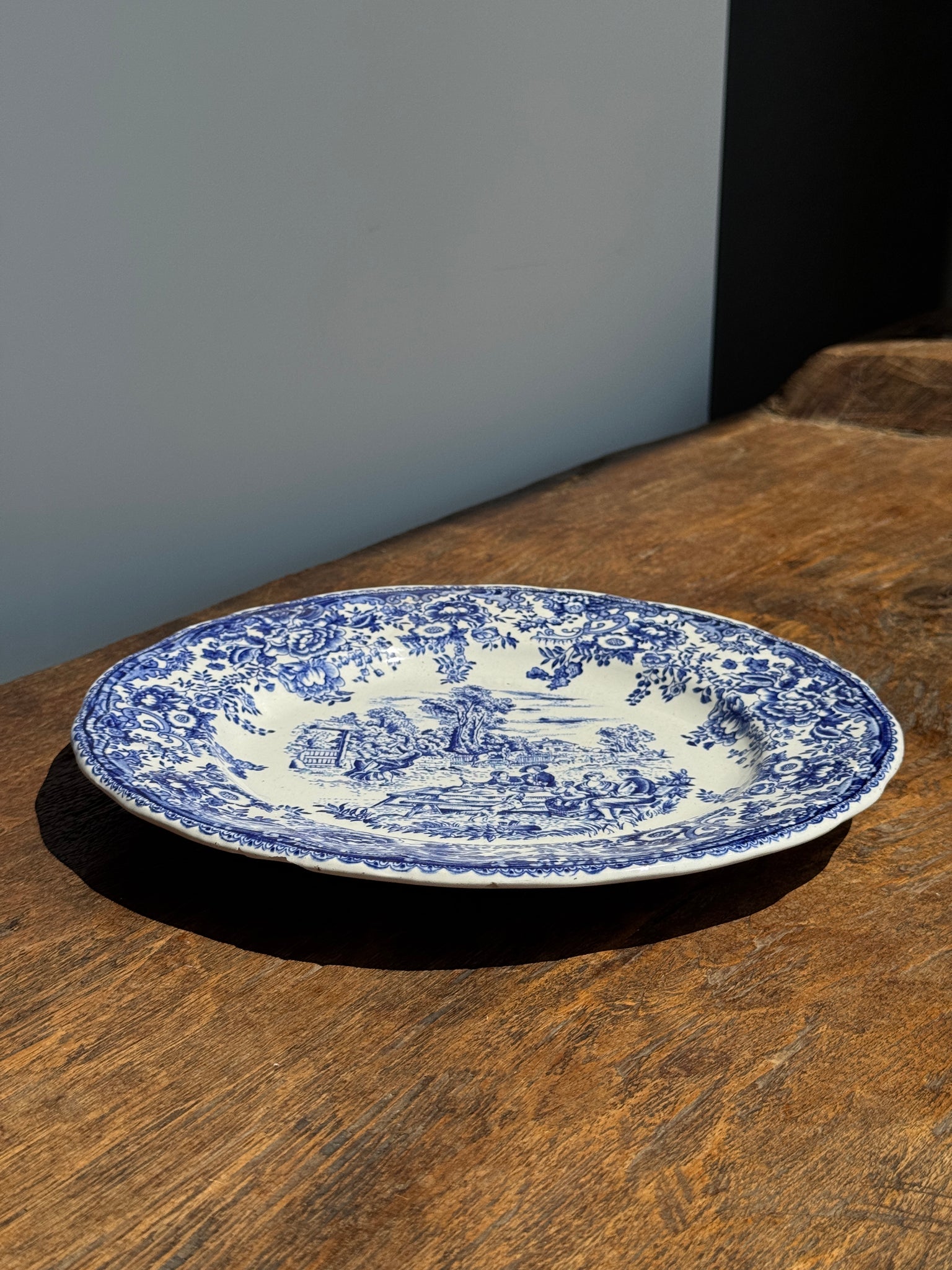 Une assiette à décor bleu en faïence BP à motif de fêtes villageoises