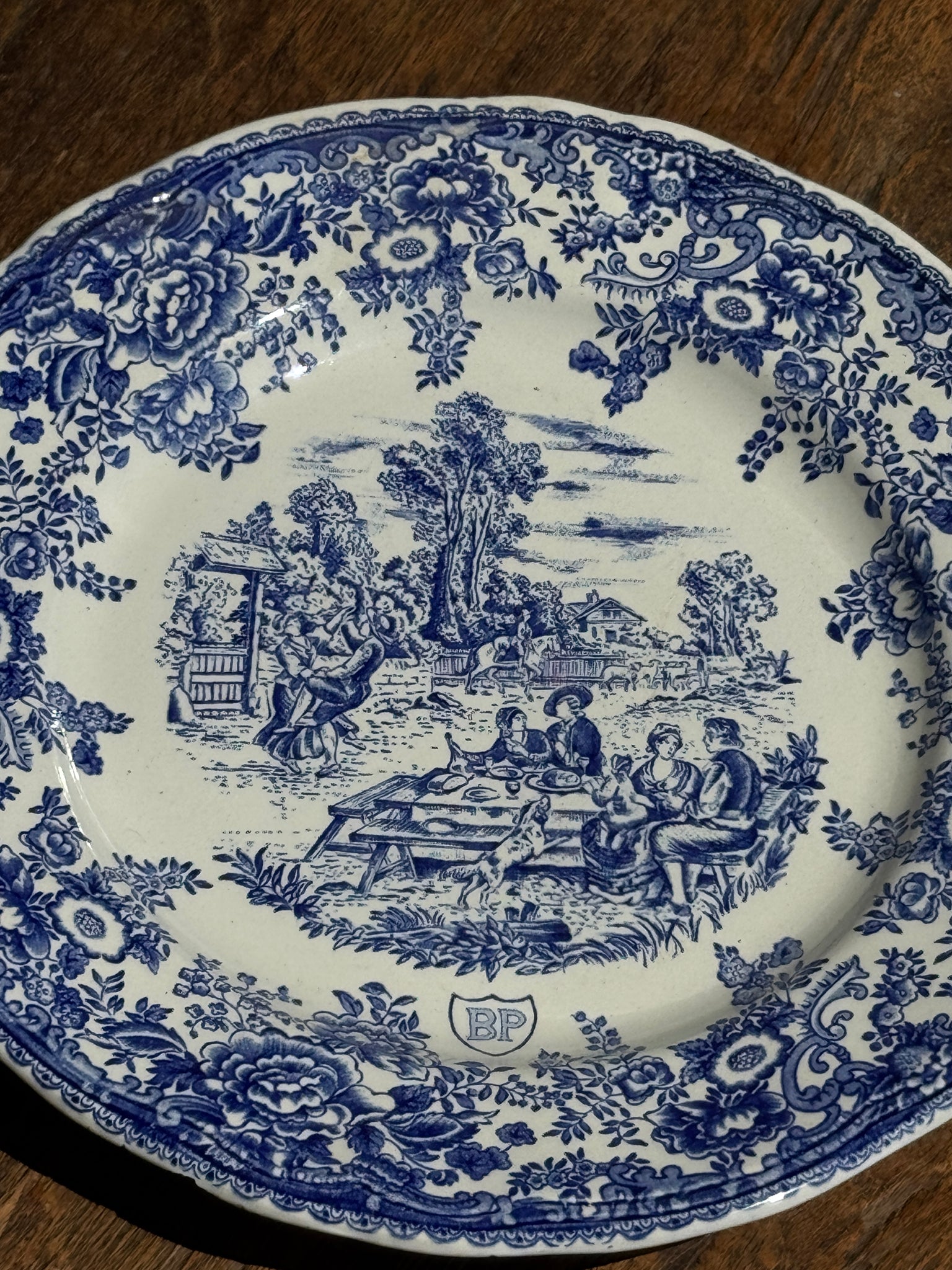 Une assiette à décor bleu en faïence BP à motif de fêtes villageoises