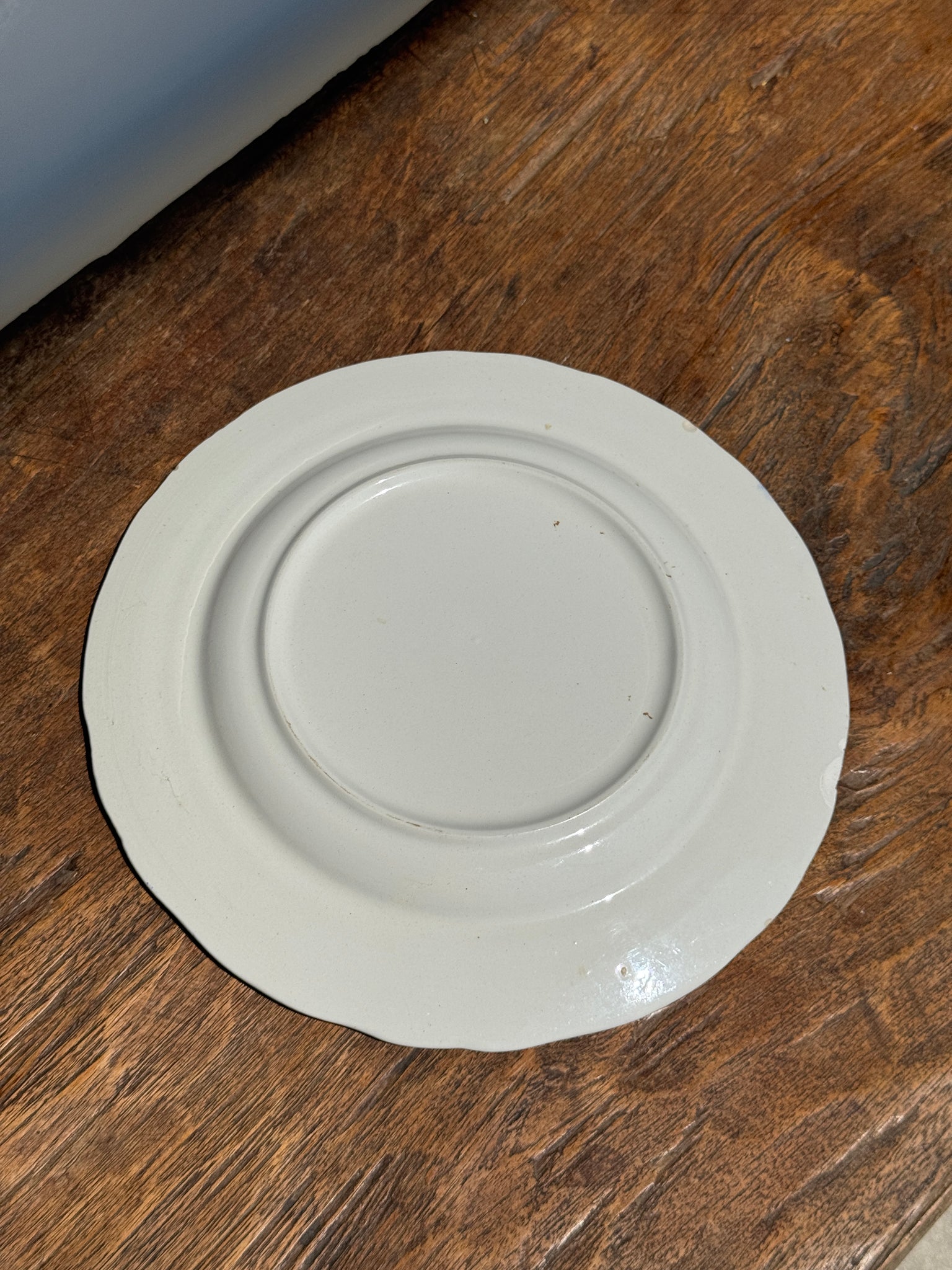 Une assiette à décor bleu en faïence BP à motif de fêtes villageoises
