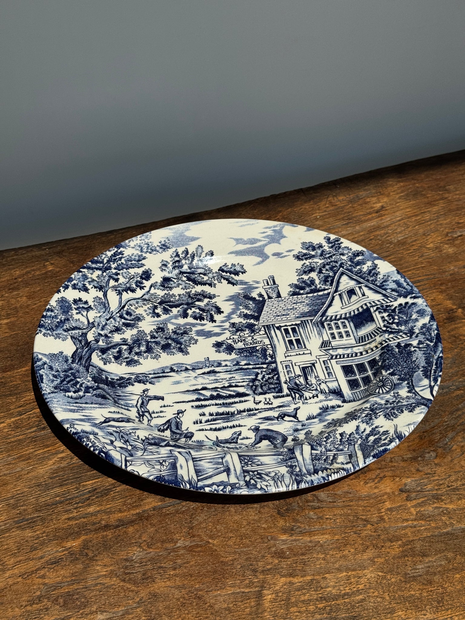 Une grande assiette plate anglaise à décor bleu motif de retour de chasse