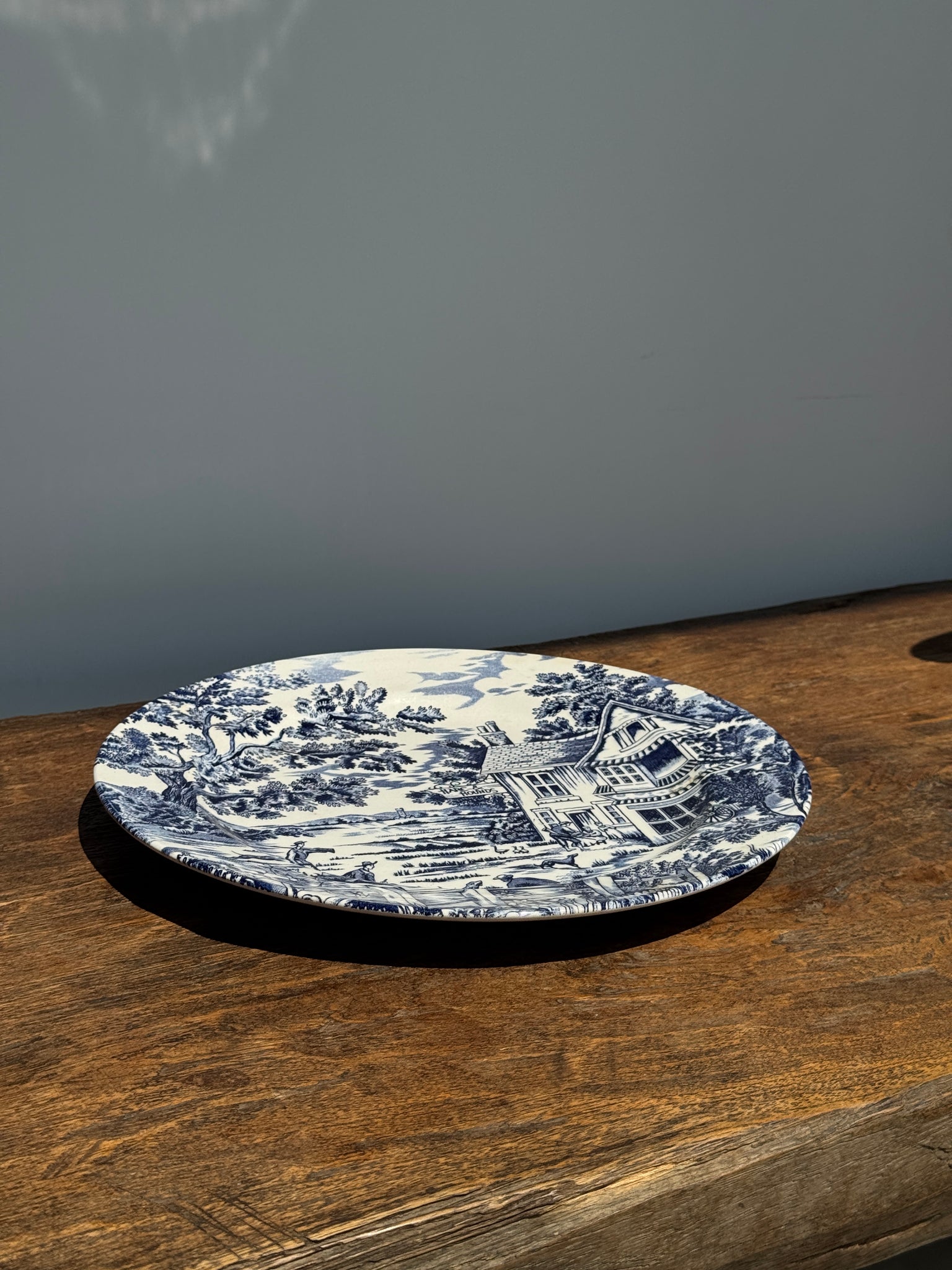 Une grande assiette plate anglaise à décor bleu motif de retour de chasse