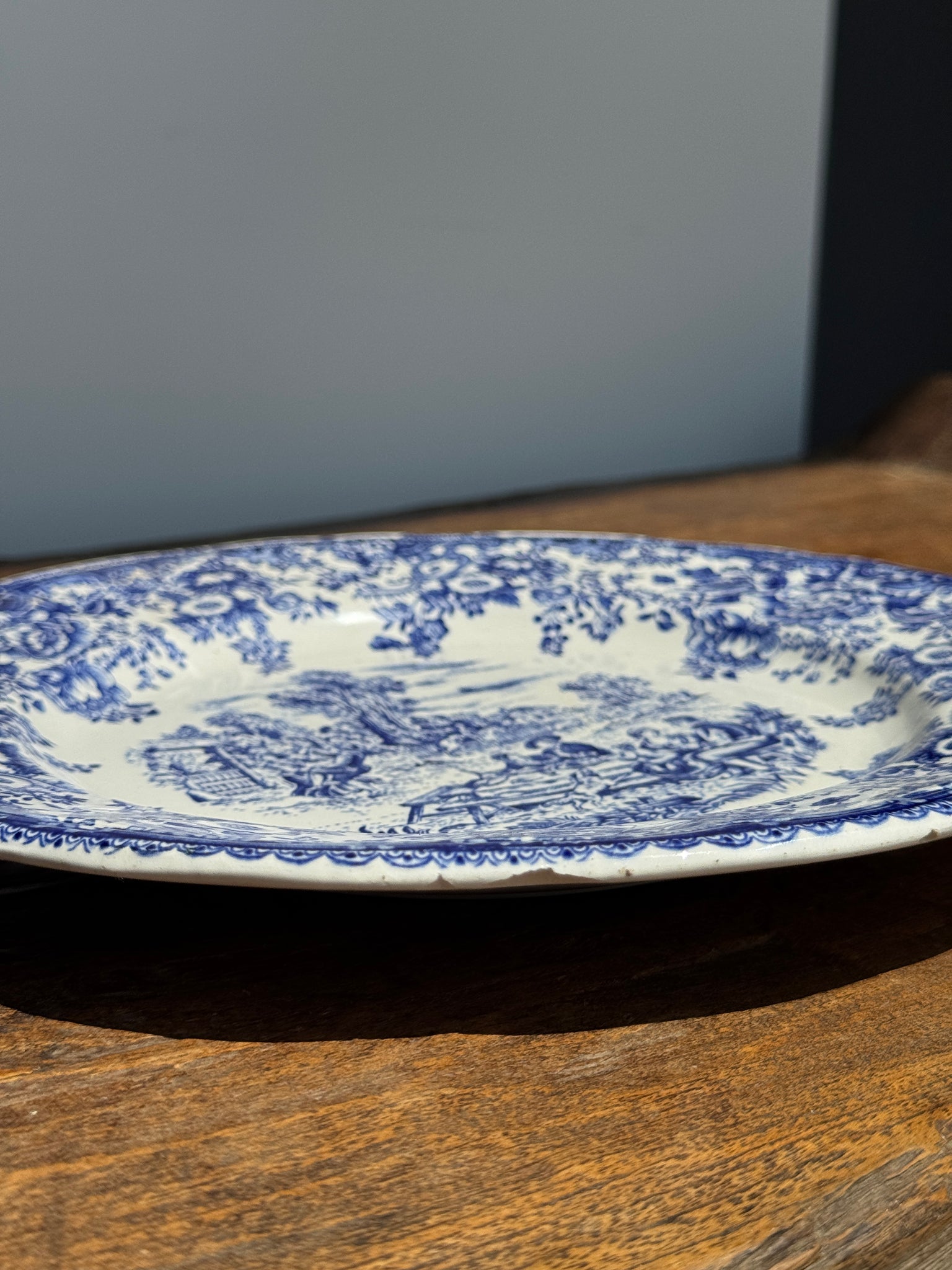 Une assiette à décor bleu en faïence BP à motif de fêtes villageoises
