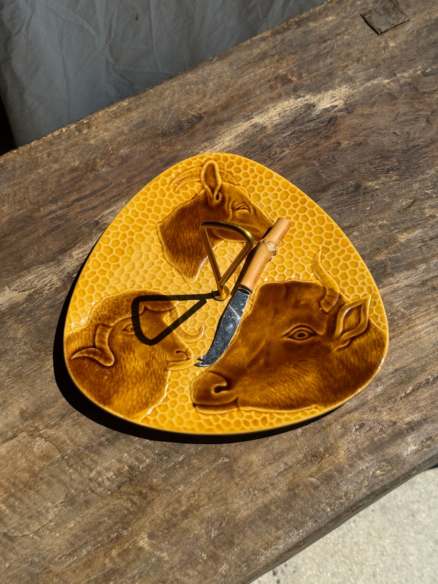 Plateau à fromage jaune figurant vache, chèvre et brebis et son couteau