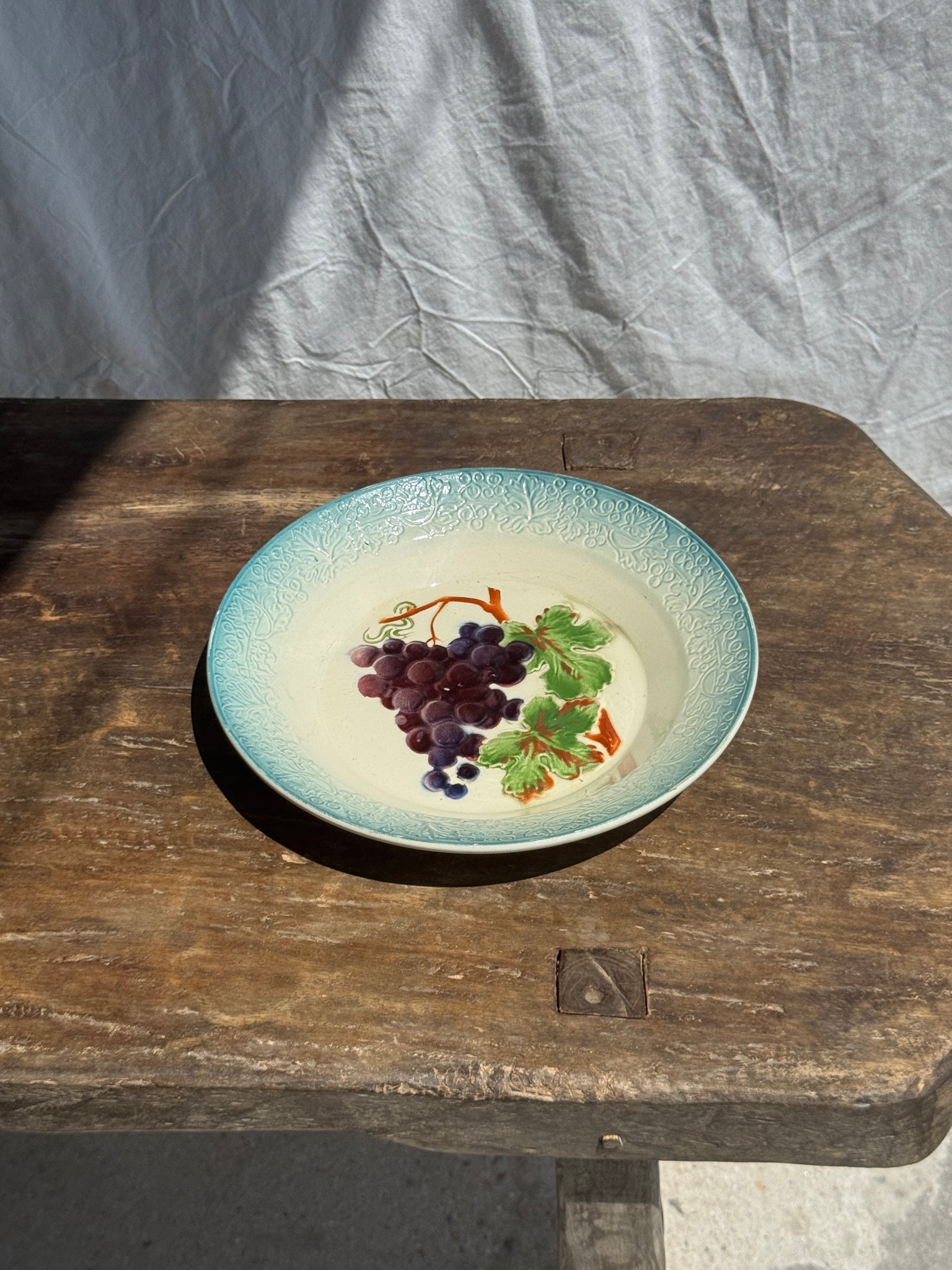 Plat creux en faïence à motifs de raisin
