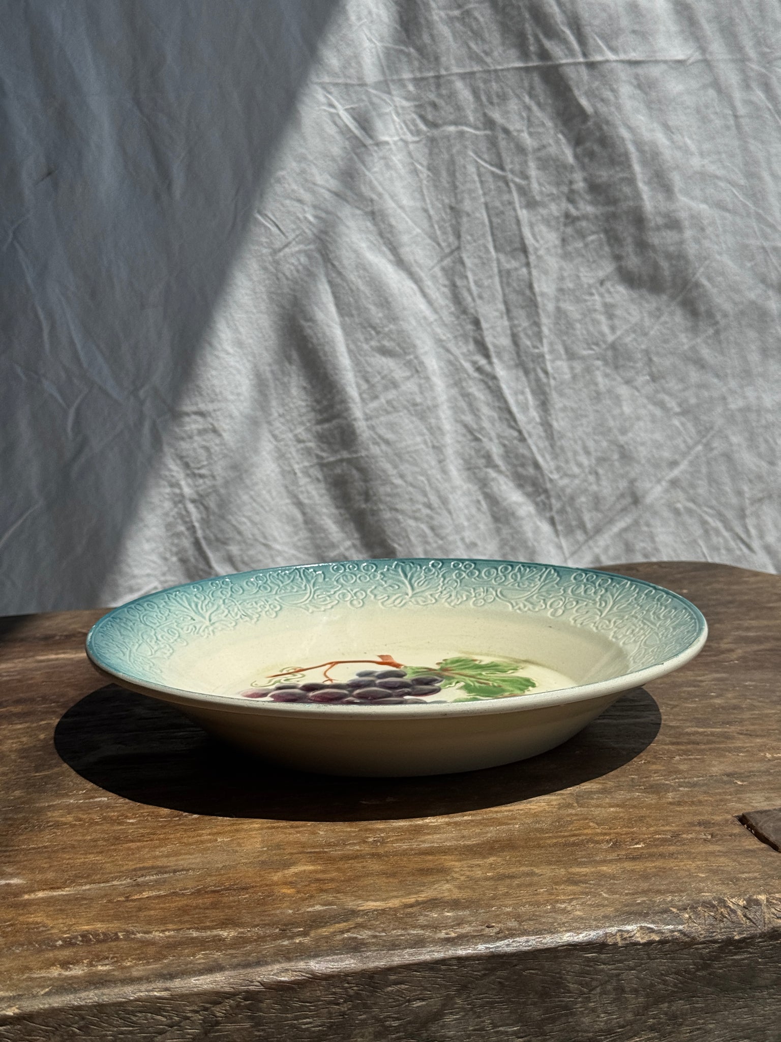 Plat creux en faïence à motifs de raisin