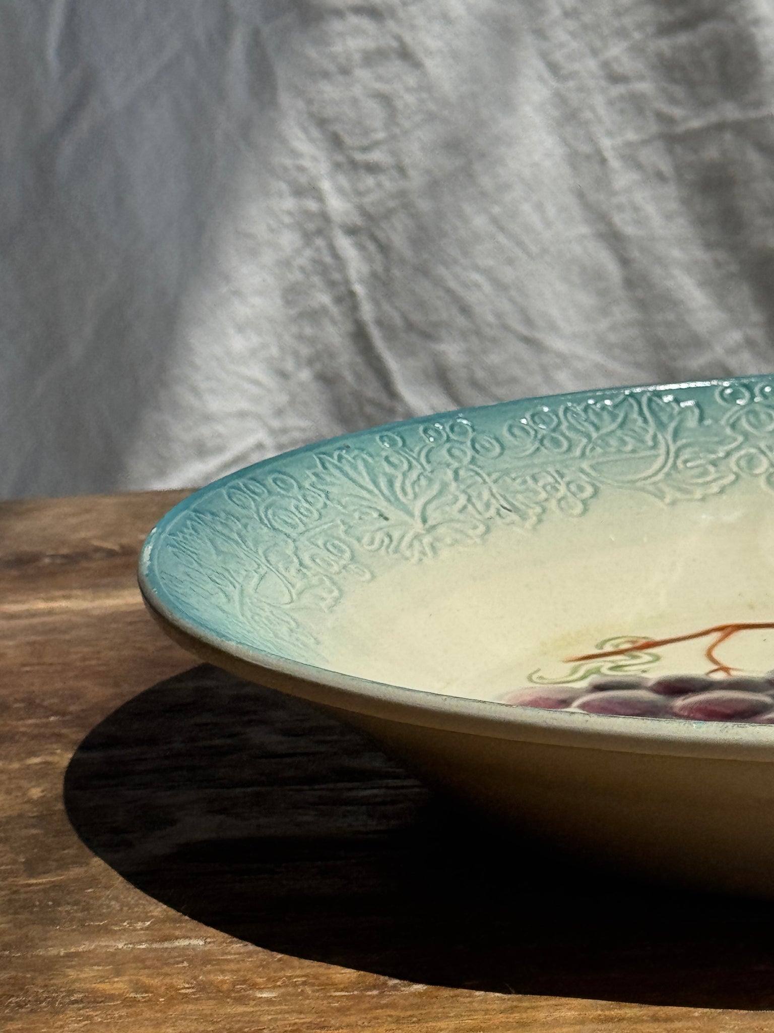Plat creux en faïence à motifs de raisin