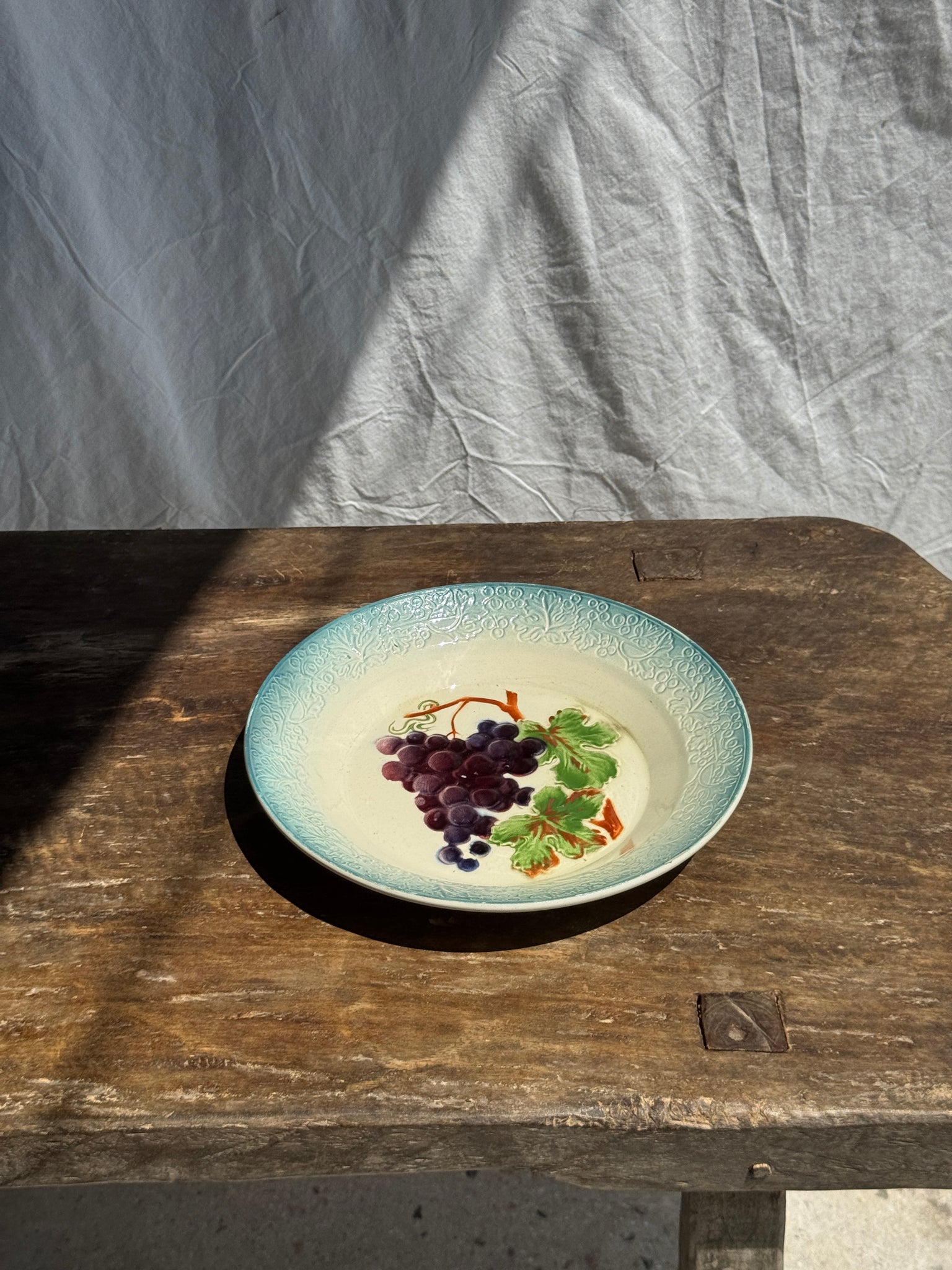 Plat creux en faïence à motifs de raisin