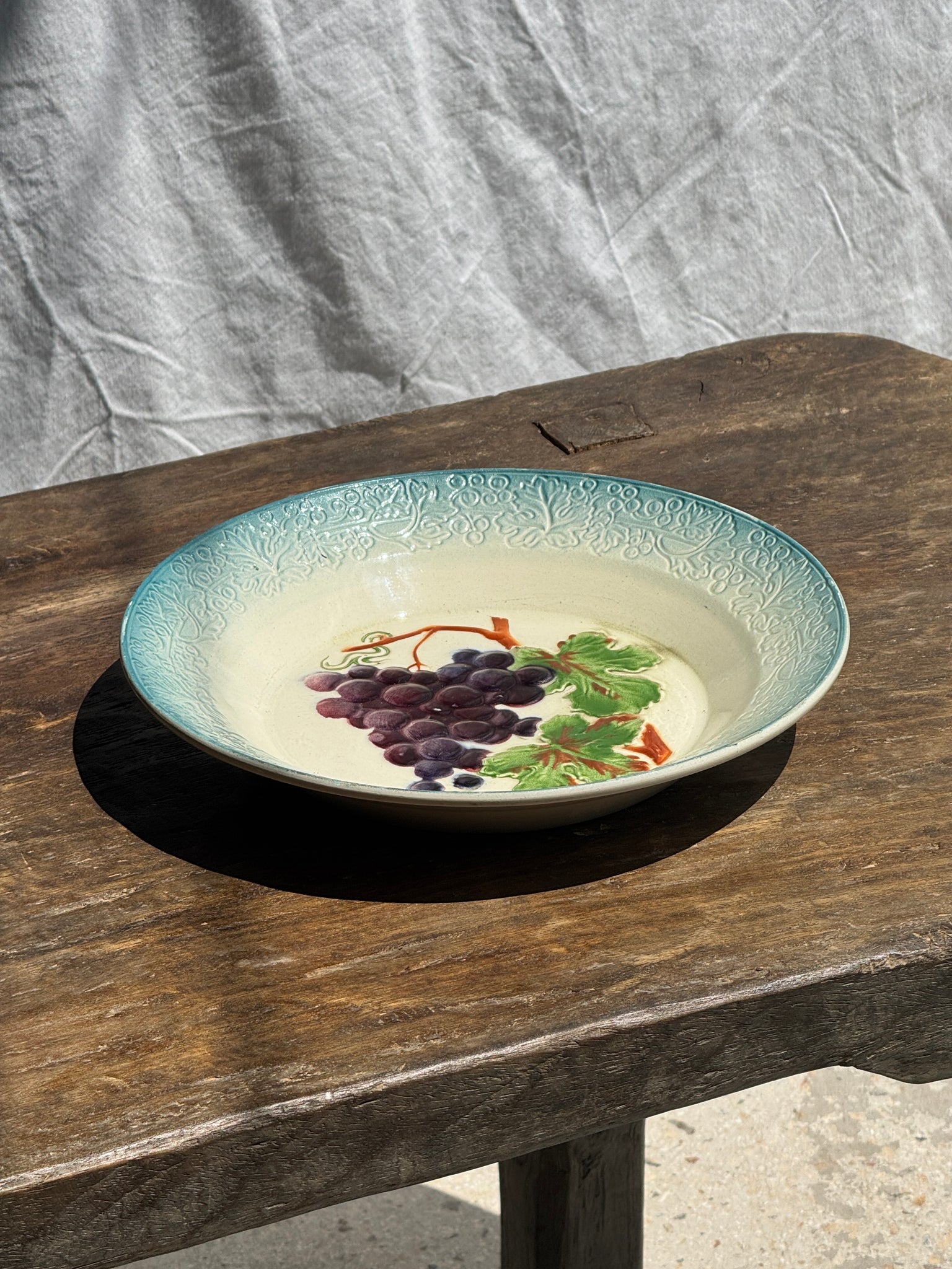 Plat creux en faïence à motifs de raisin