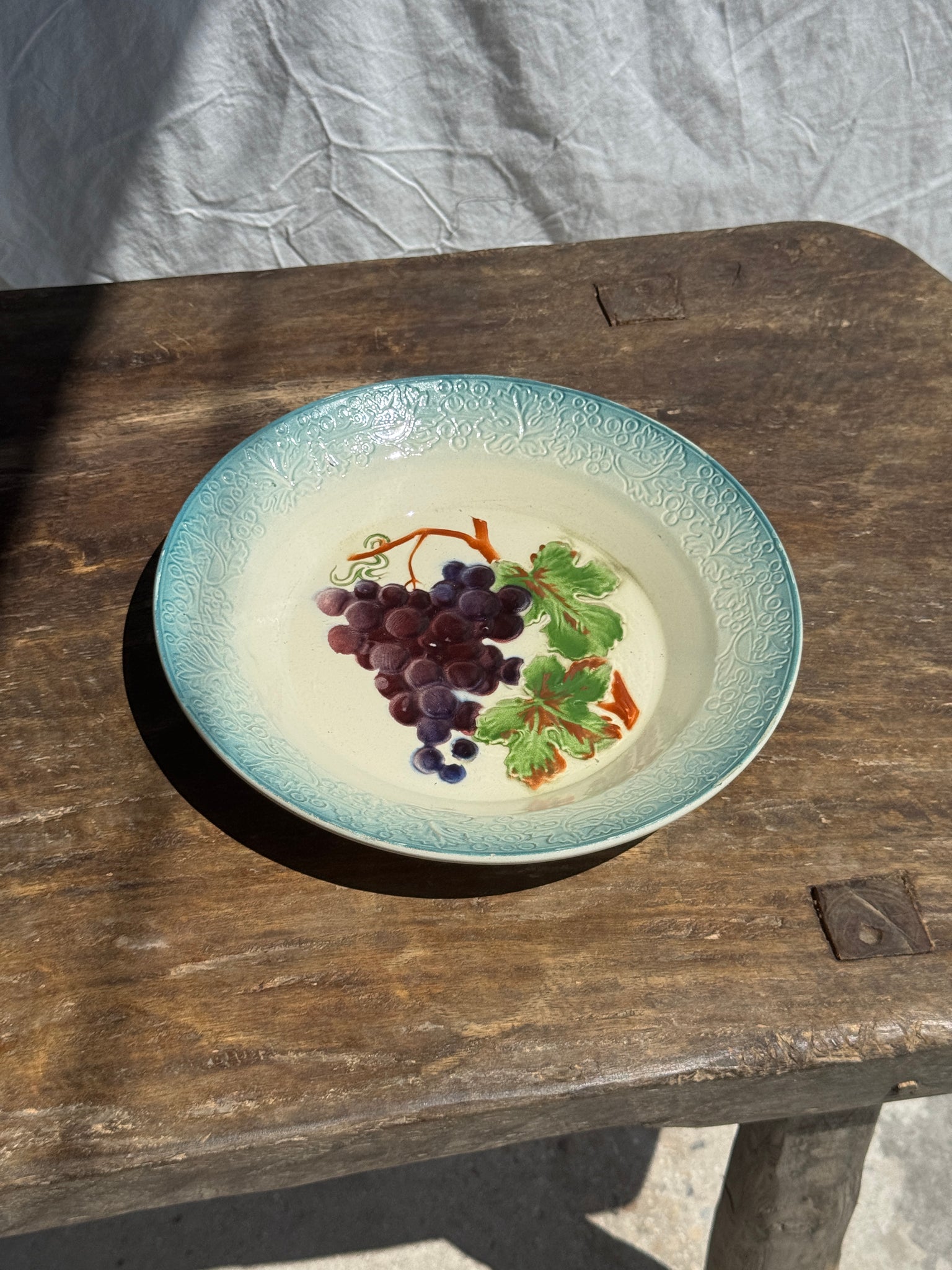 Plat creux en faïence à motifs de raisin