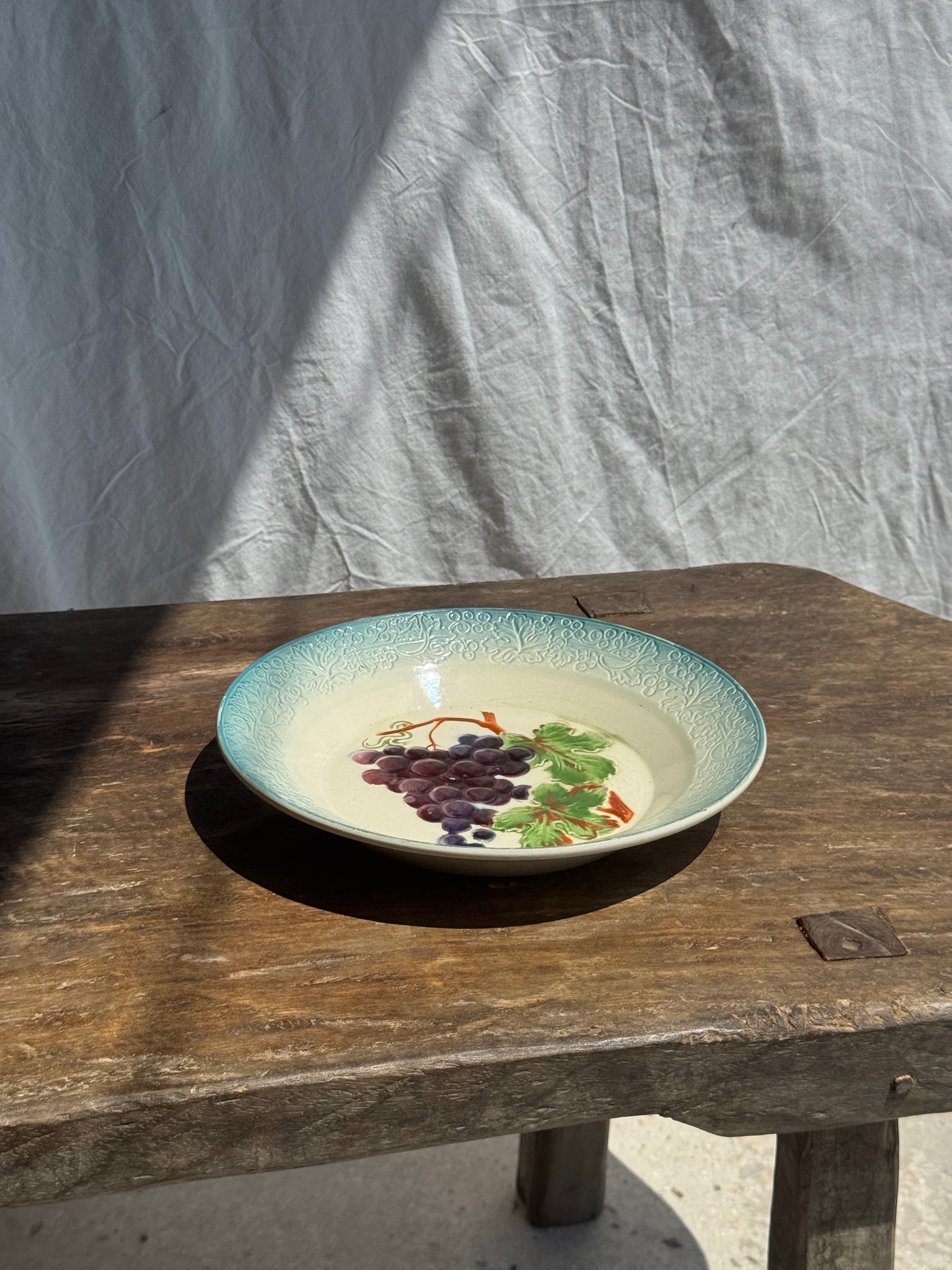 Plat creux en faïence à motifs de raisin