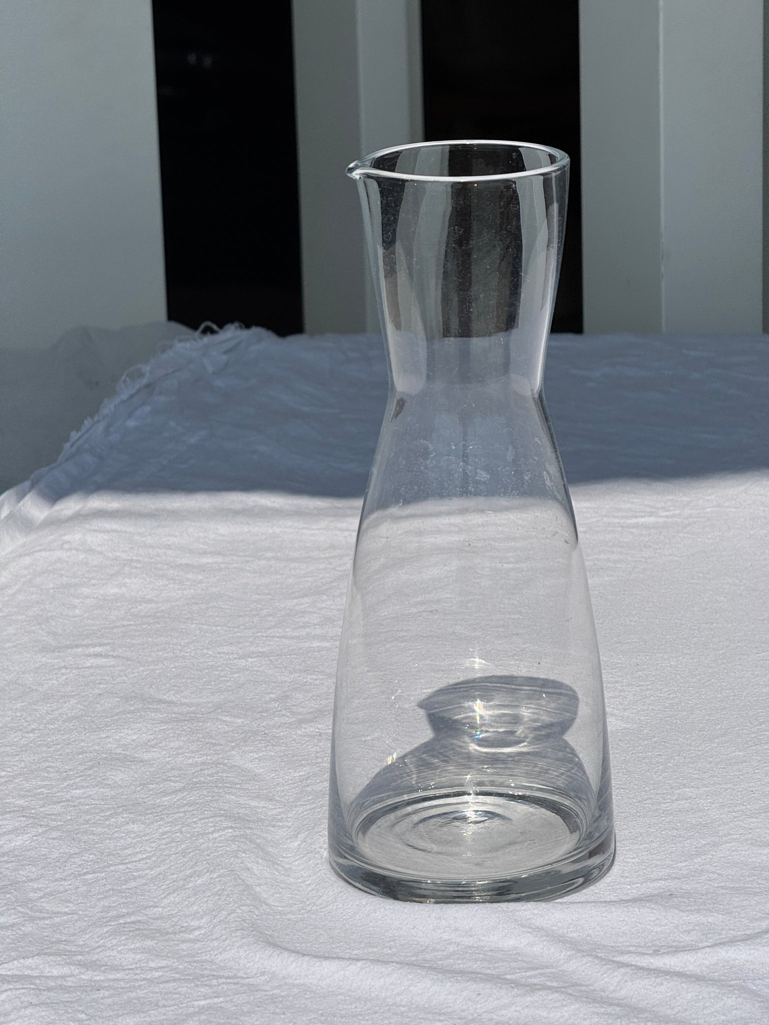 Une grande carafe en verre minimaliste à petit bec