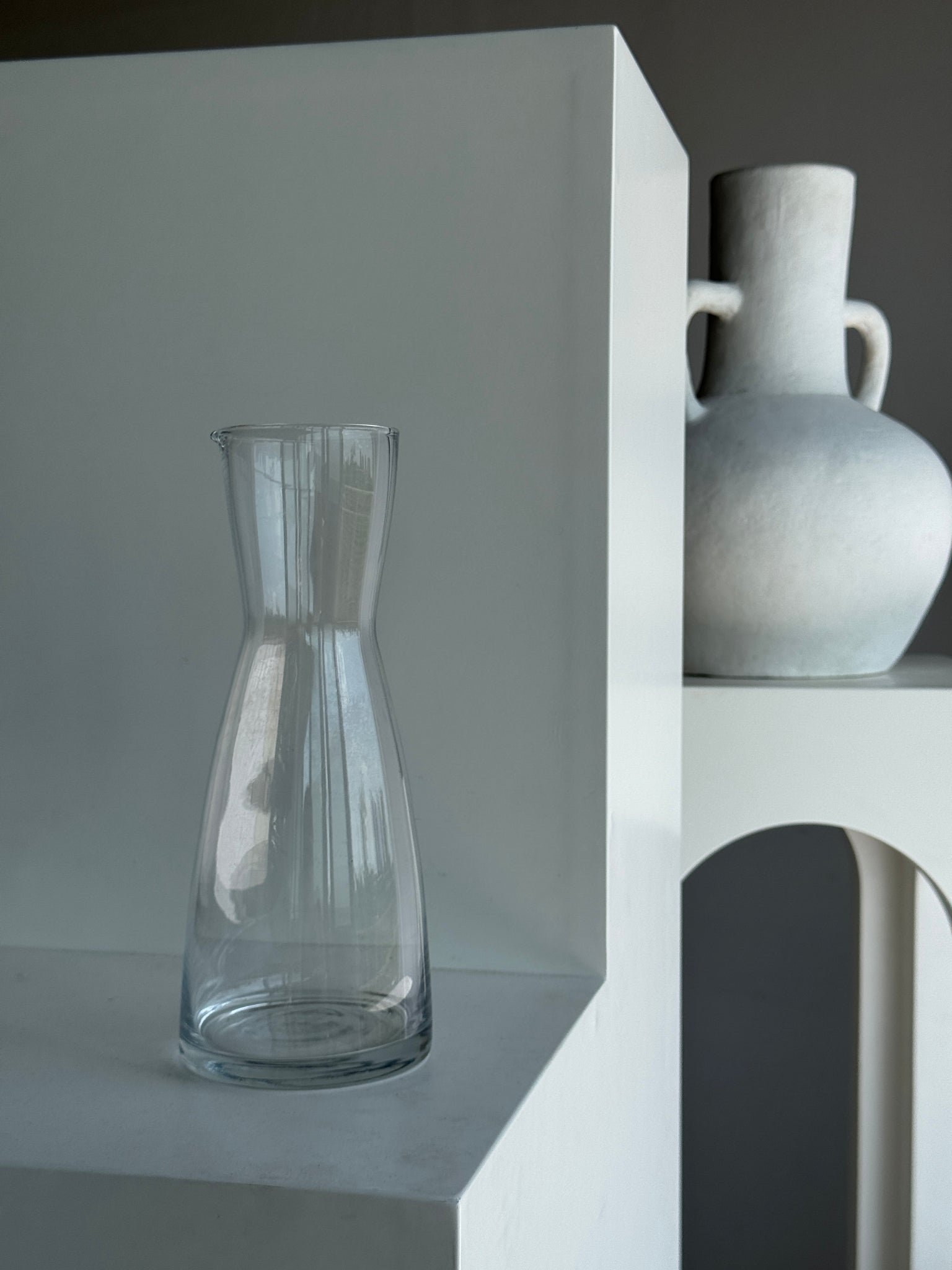 Une grande carafe en verre minimaliste à petit bec