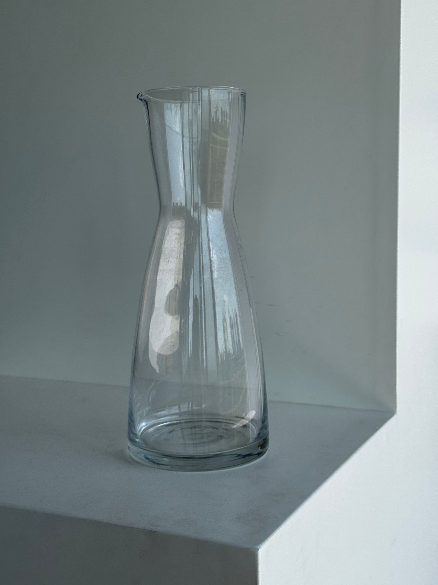 Une grande carafe en verre minimaliste à petit bec