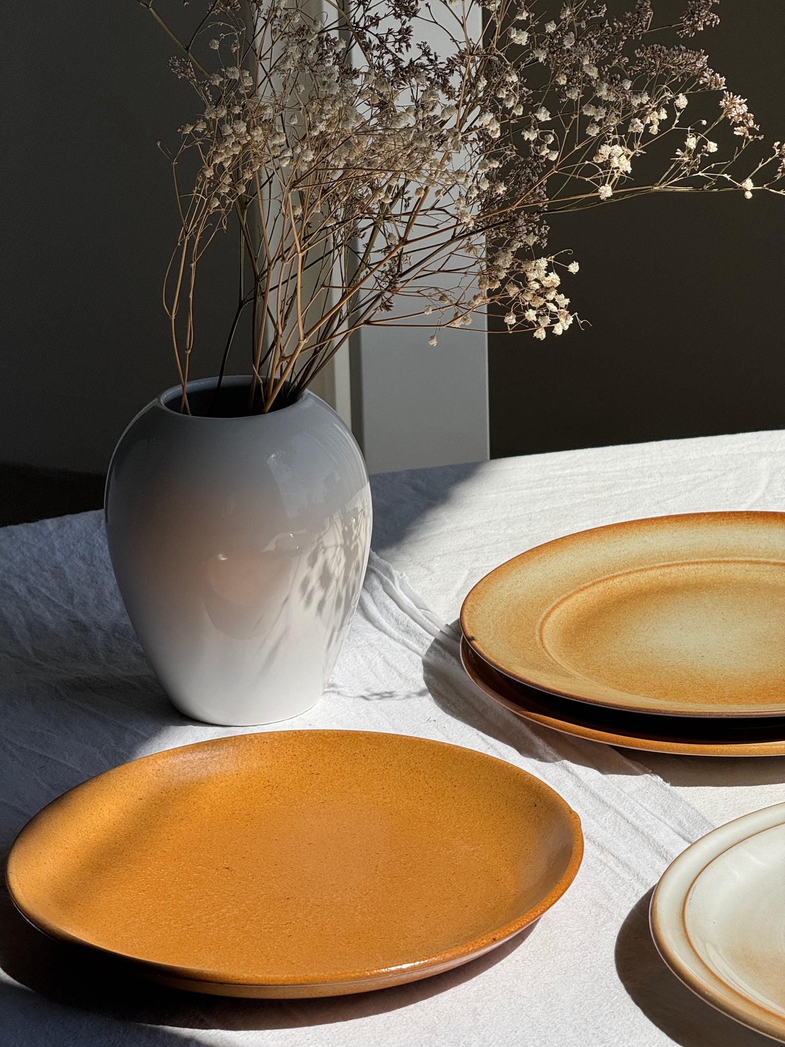 Réunion de 4 assiettes en grès vintage dont 2 avec des motifs de fleurs stylisées