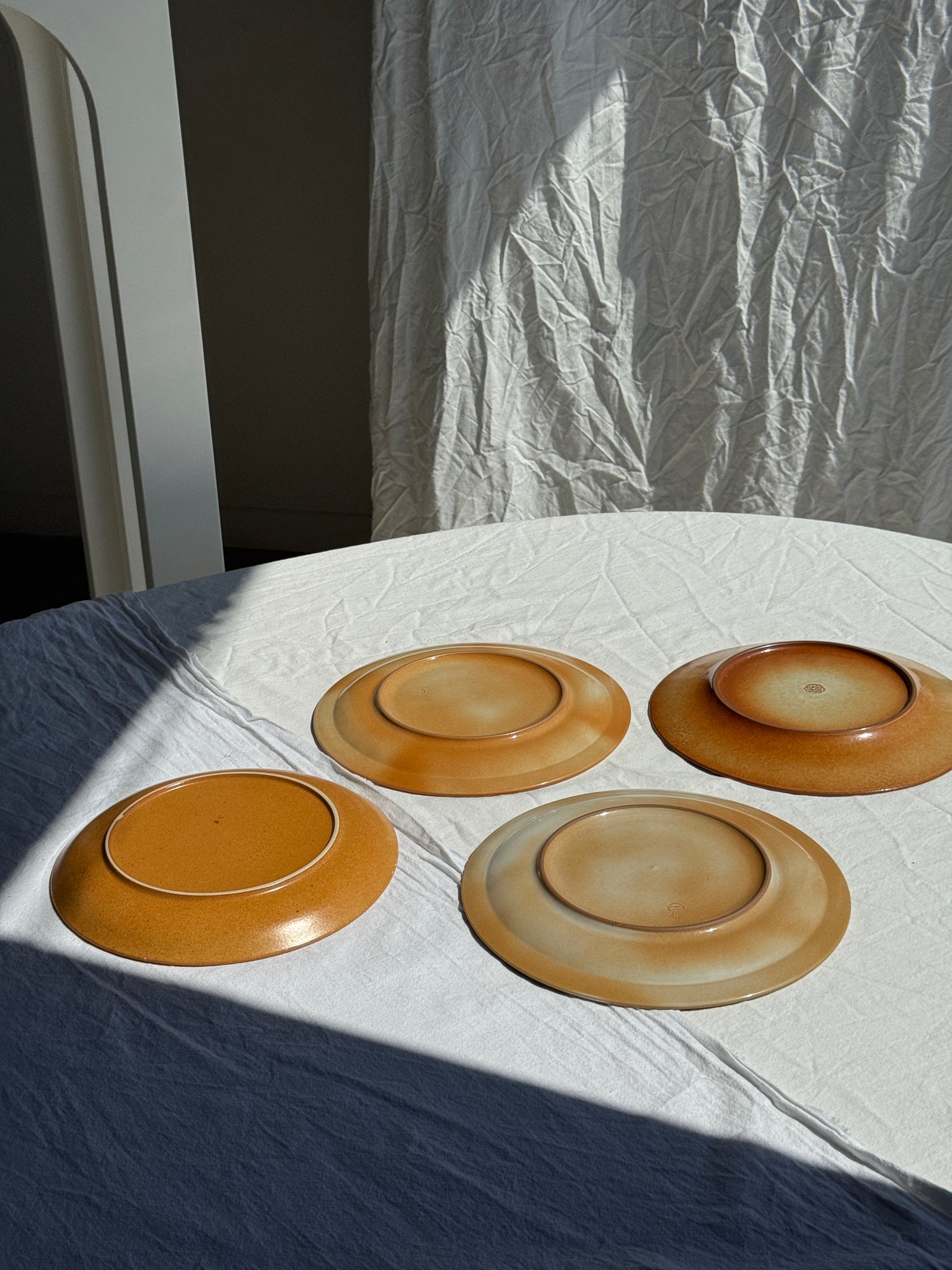 Réunion de 4 assiettes en grès vintage dont 2 avec des motifs de fleurs stylisées