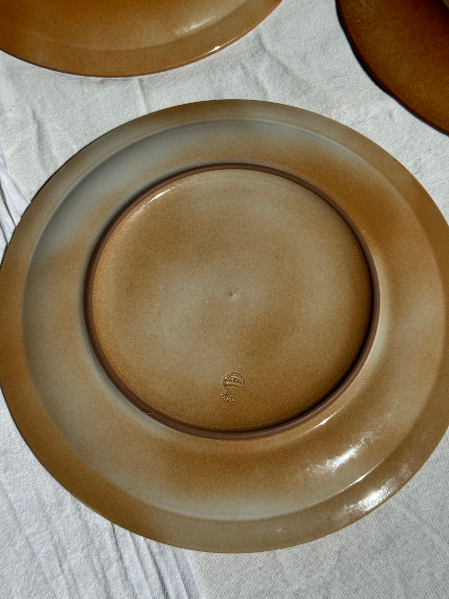 Réunion de 4 assiettes en grès vintage dont 2 avec des motifs de fleurs stylisées
