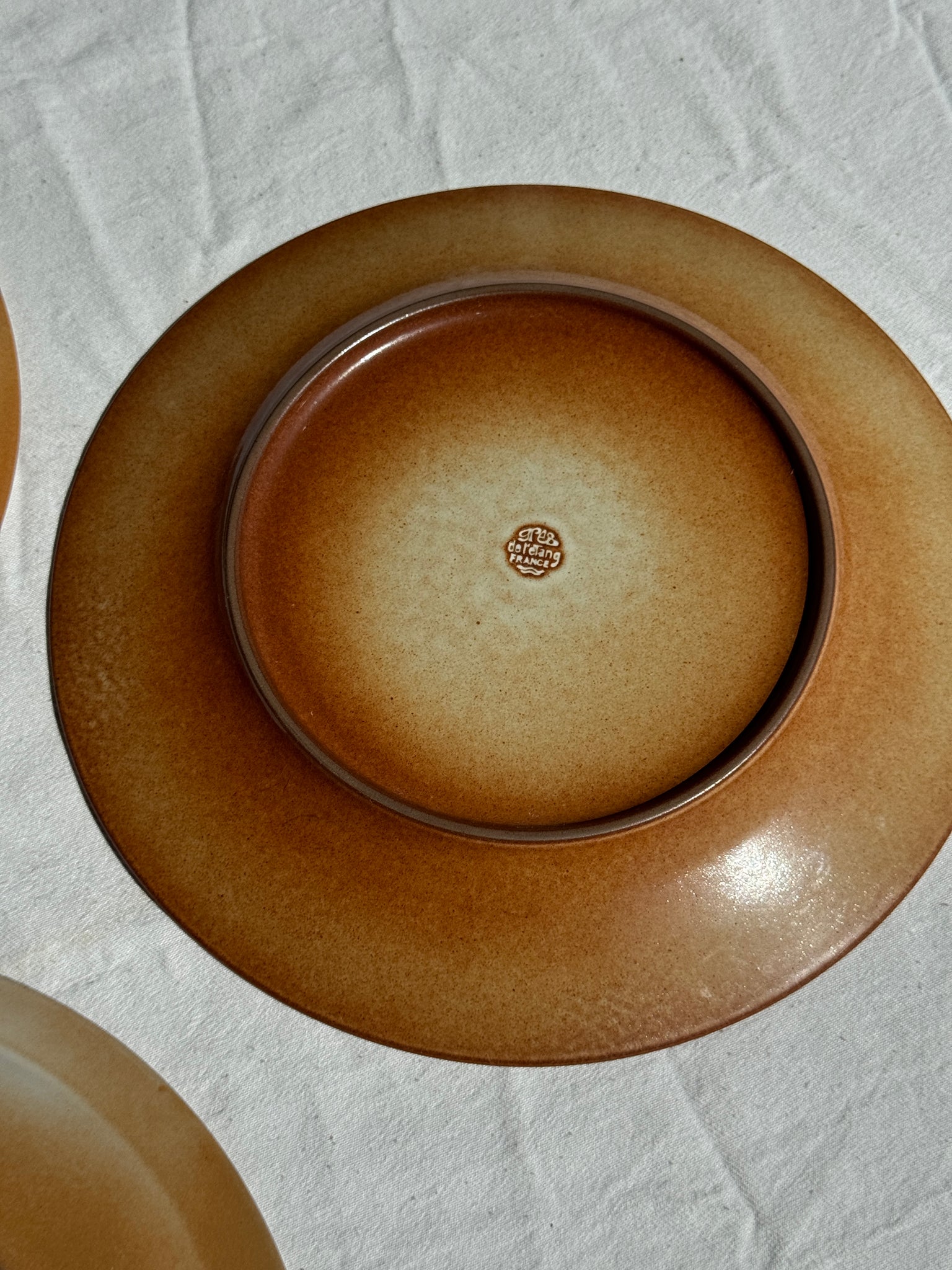 Réunion de 4 assiettes en grès vintage dont 2 avec des motifs de fleurs stylisées