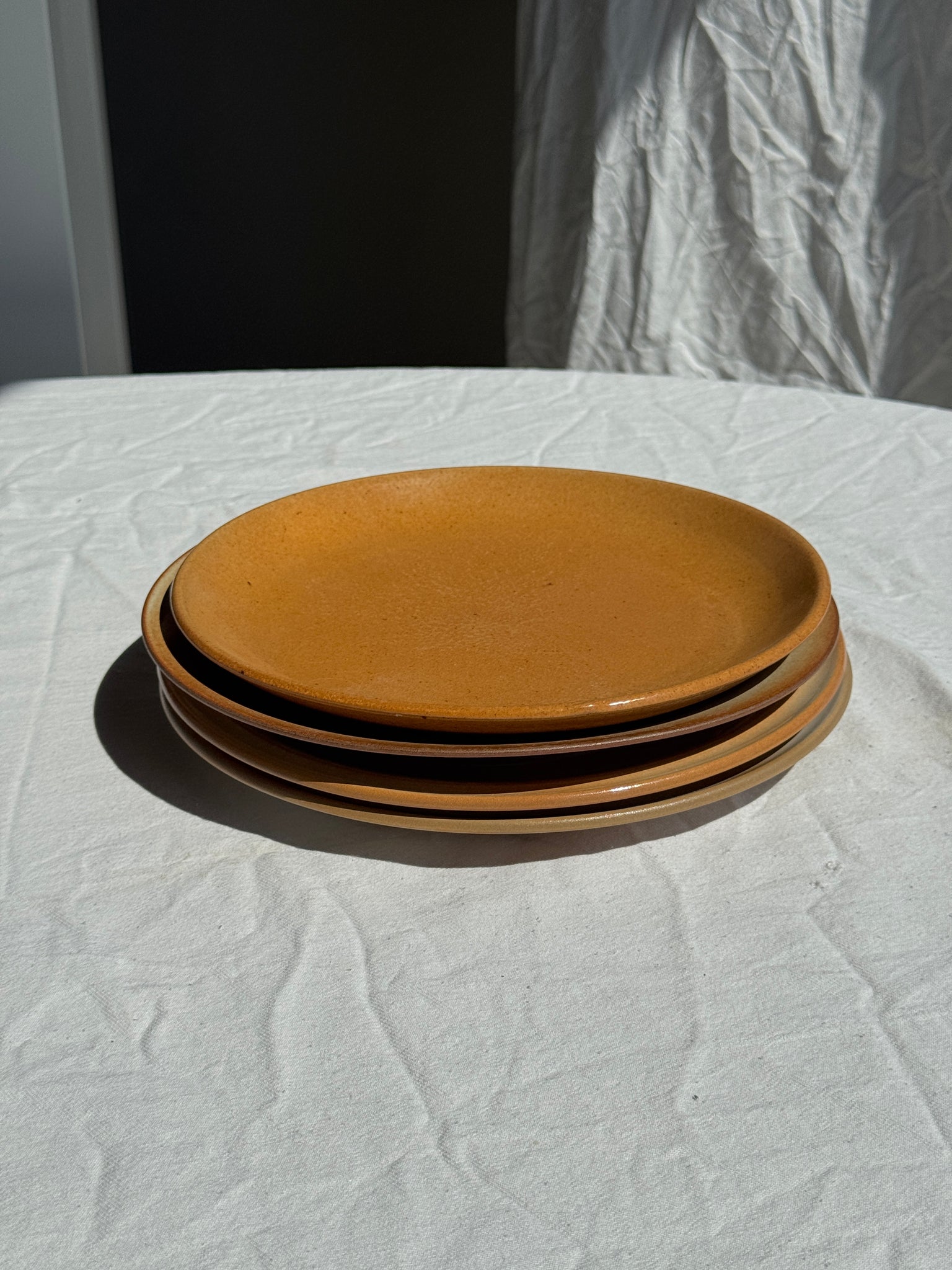 Réunion de 4 assiettes en grès vintage dont 2 avec des motifs de fleurs stylisées