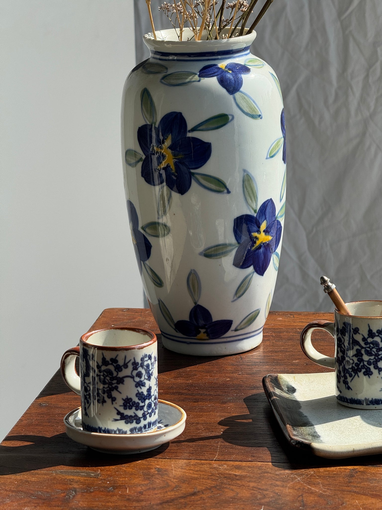 Vase fond blanc fleurs bleues jaunes et vertes stylisées H24,5 D12