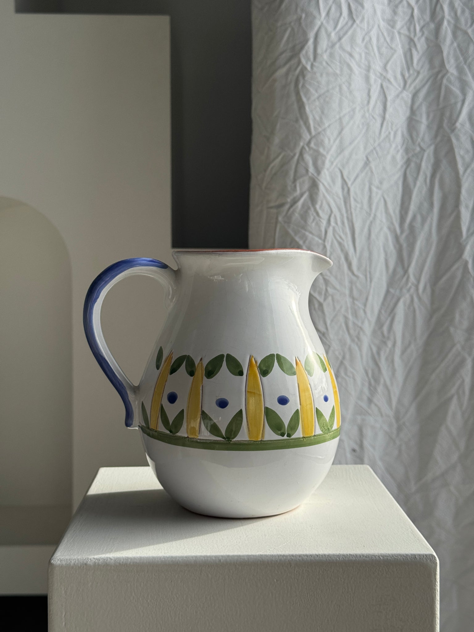 Grande carafe blanche en terre cuite à motif de frise stylisée verte jaune et bleue H20 D17
