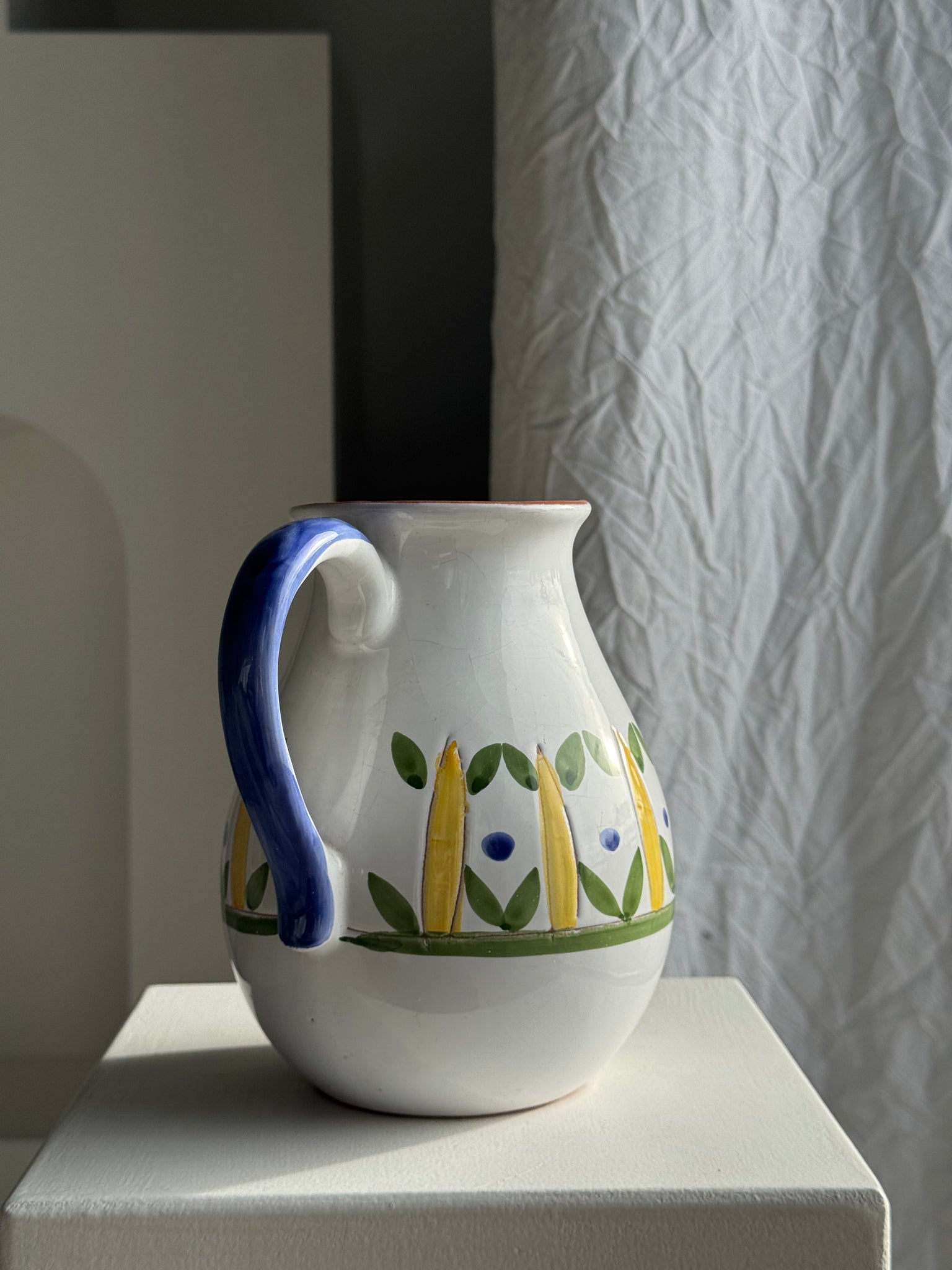 Grande carafe blanche en terre cuite à motif de frise stylisée verte jaune et bleue H20 D17