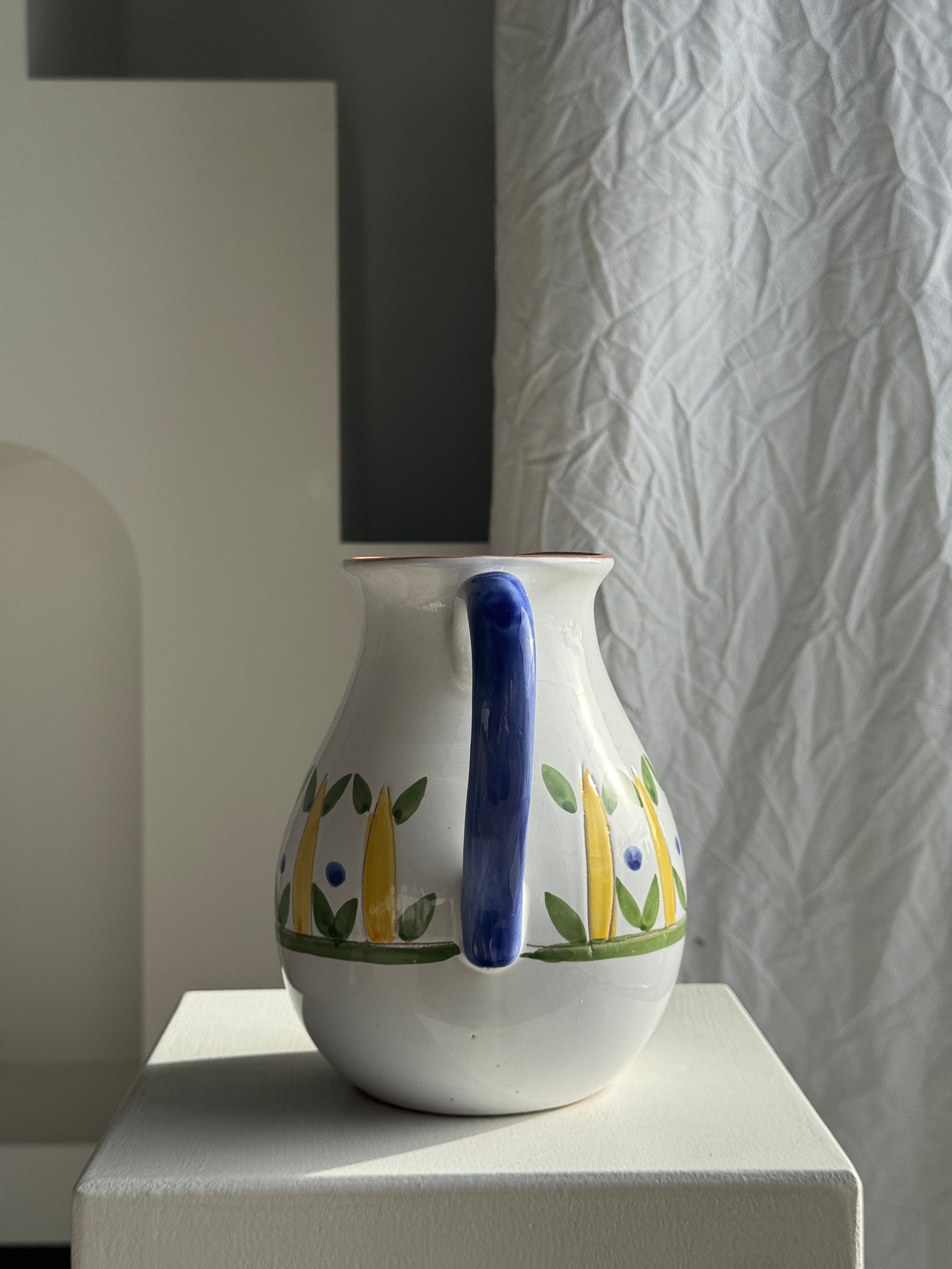 Grande carafe blanche en terre cuite à motif de frise stylisée verte jaune et bleue H20 D17