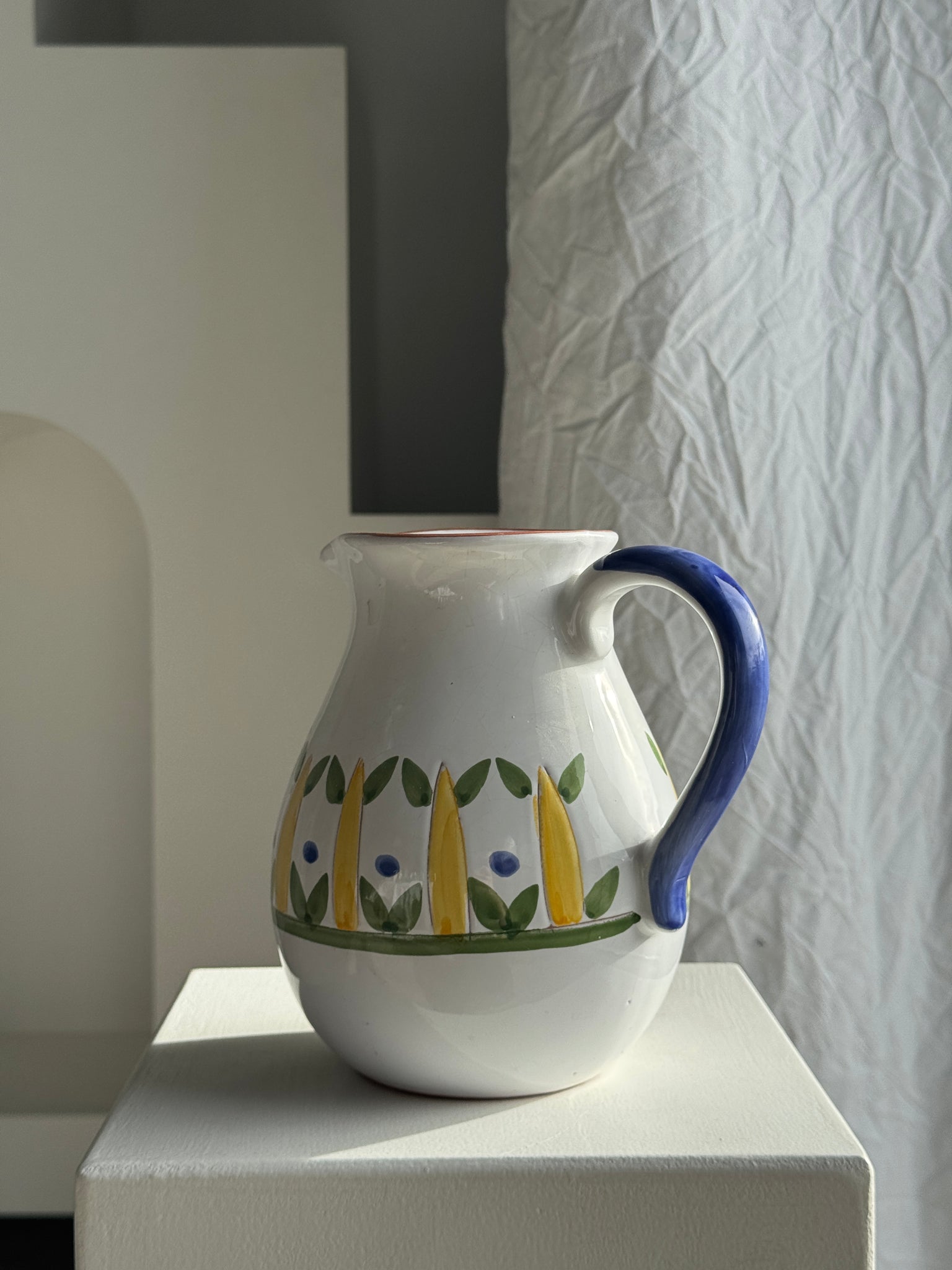 Grande carafe blanche en terre cuite à motif de frise stylisée verte jaune et bleue H20 D17