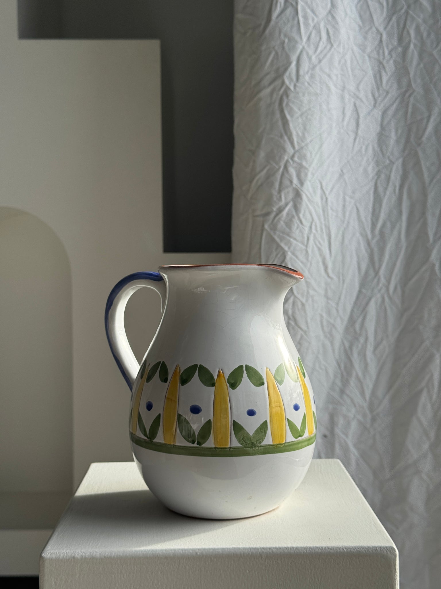 Grande carafe blanche en terre cuite à motif de frise stylisée verte jaune et bleue H20 D17