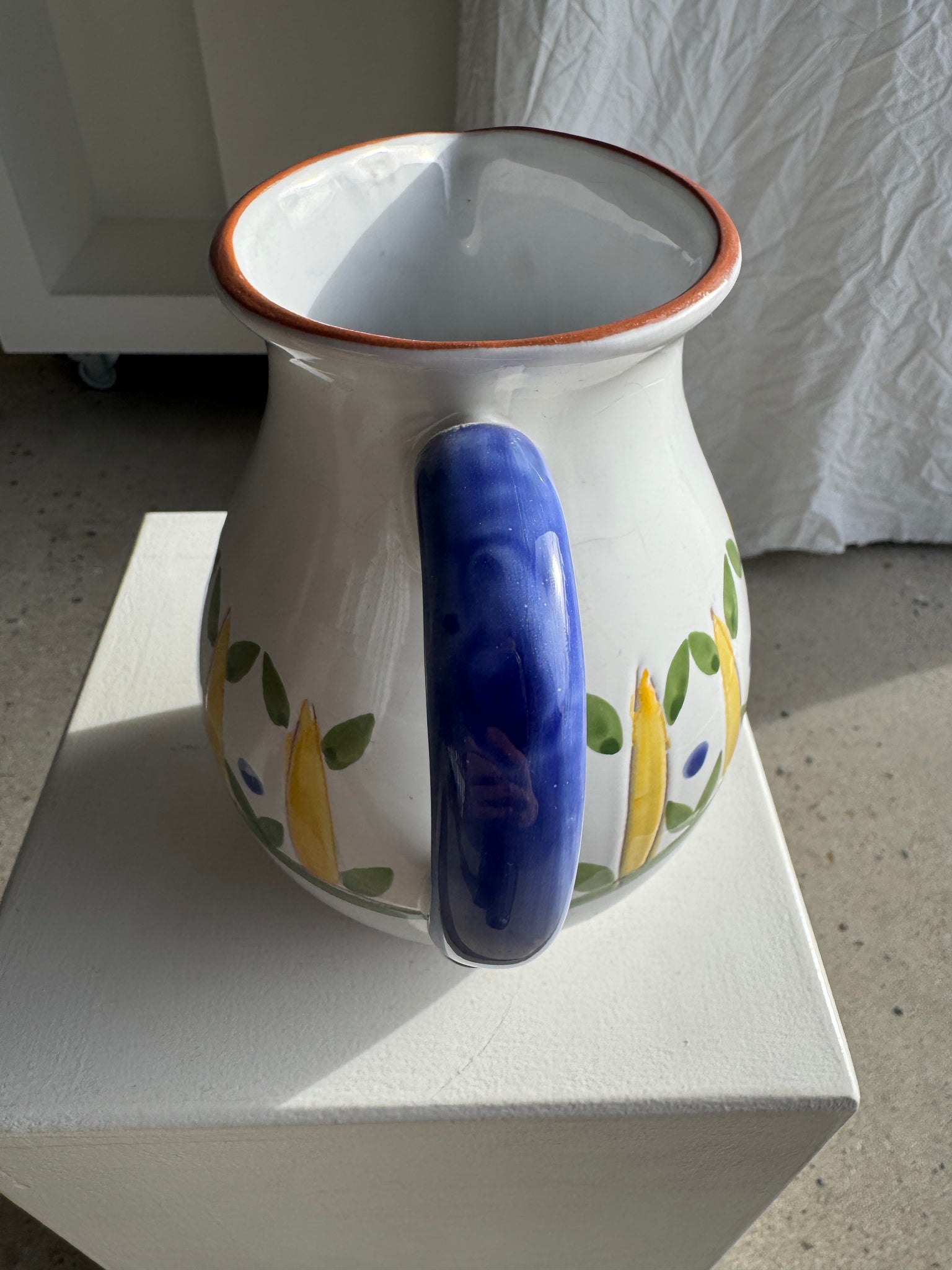 Grande carafe blanche en terre cuite à motif de frise stylisée verte jaune et bleue H20 D17