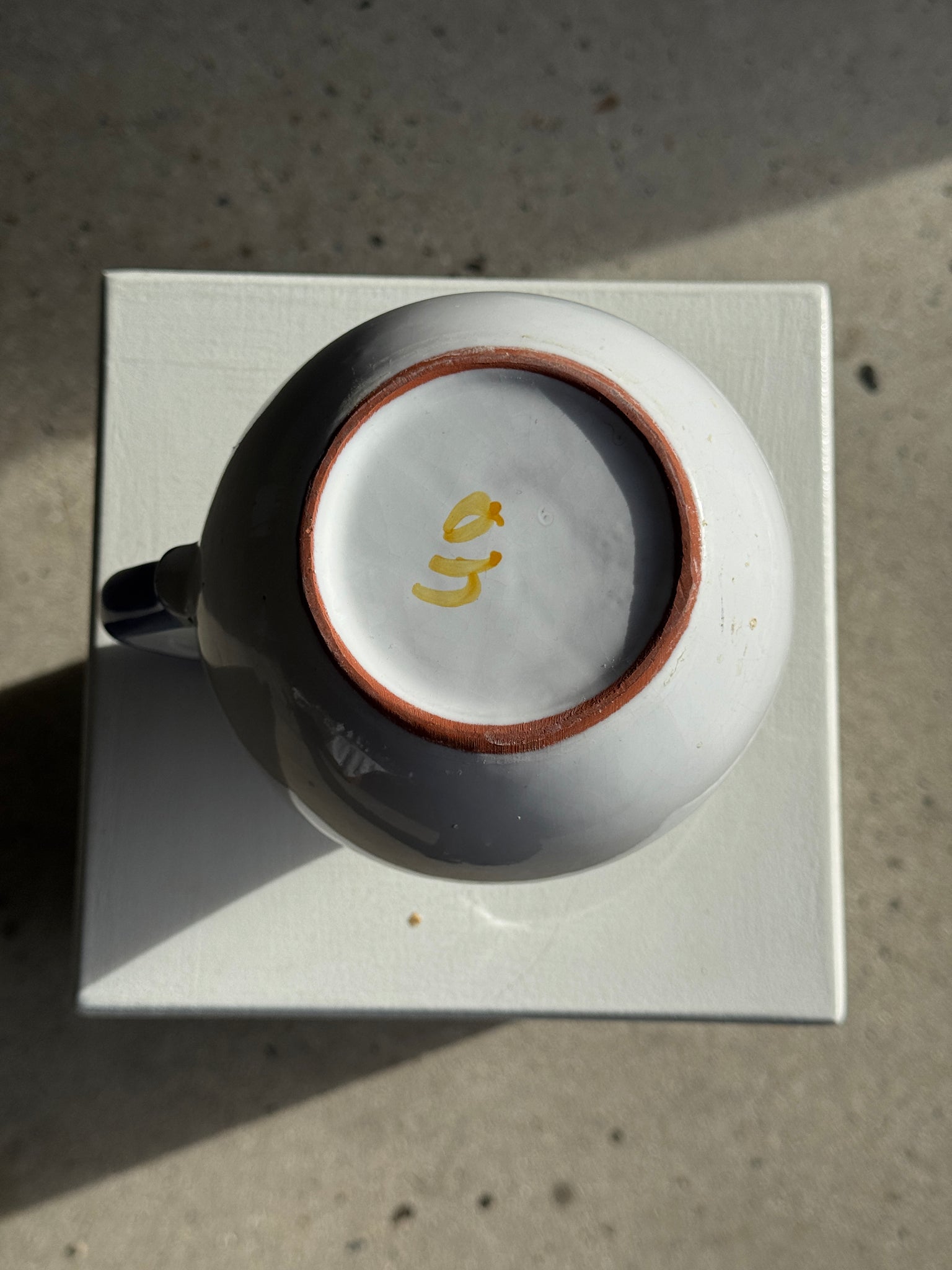 Grande carafe blanche en terre cuite à motif de frise stylisée verte jaune et bleue H20 D17