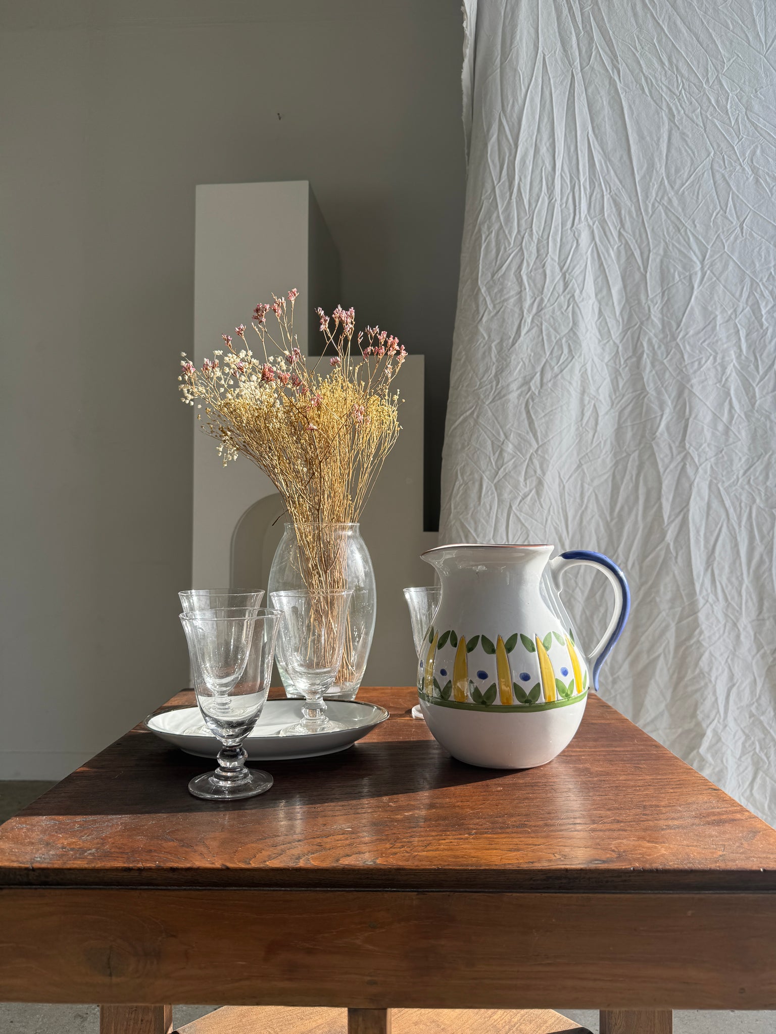 Grande carafe blanche en terre cuite à motif de frise stylisée verte jaune et bleue H20 D17