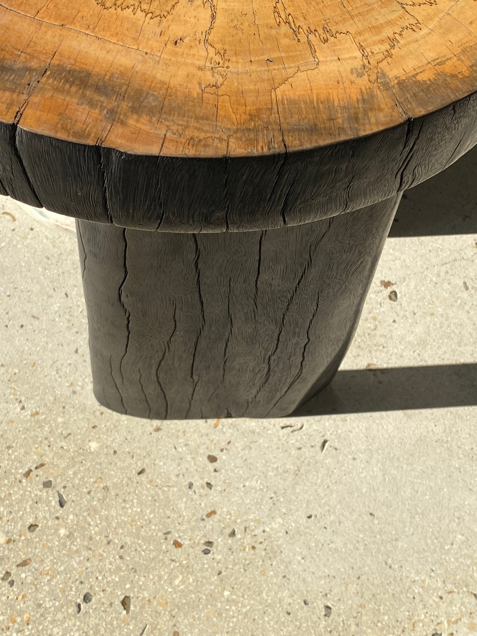 Tabouret en tamarin massif, assise demi circulaire tranche et pieds noircis