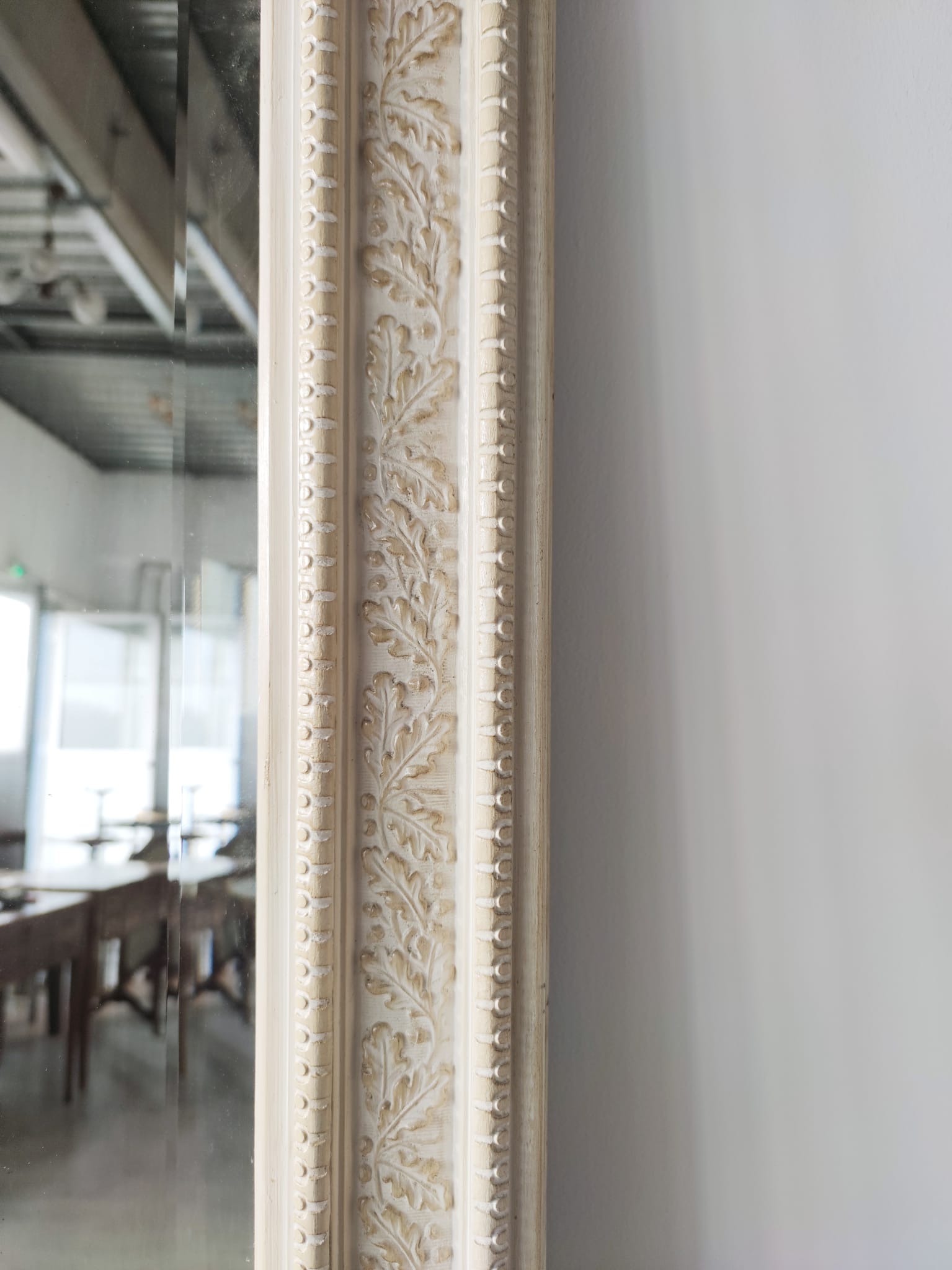 Grand miroir biseauté en bois laqué blanc à décor de frises de feuilles de chêne H:1m74
