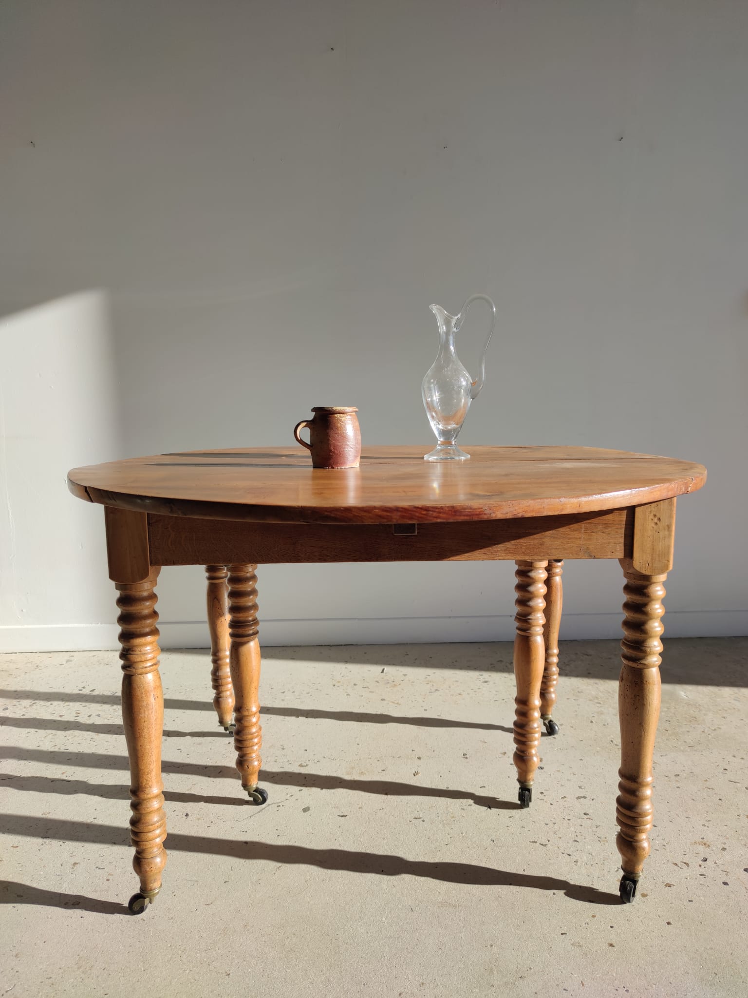 Table de salle à manger circulaire en bois naturel, 6 pieds tournés à roulettes