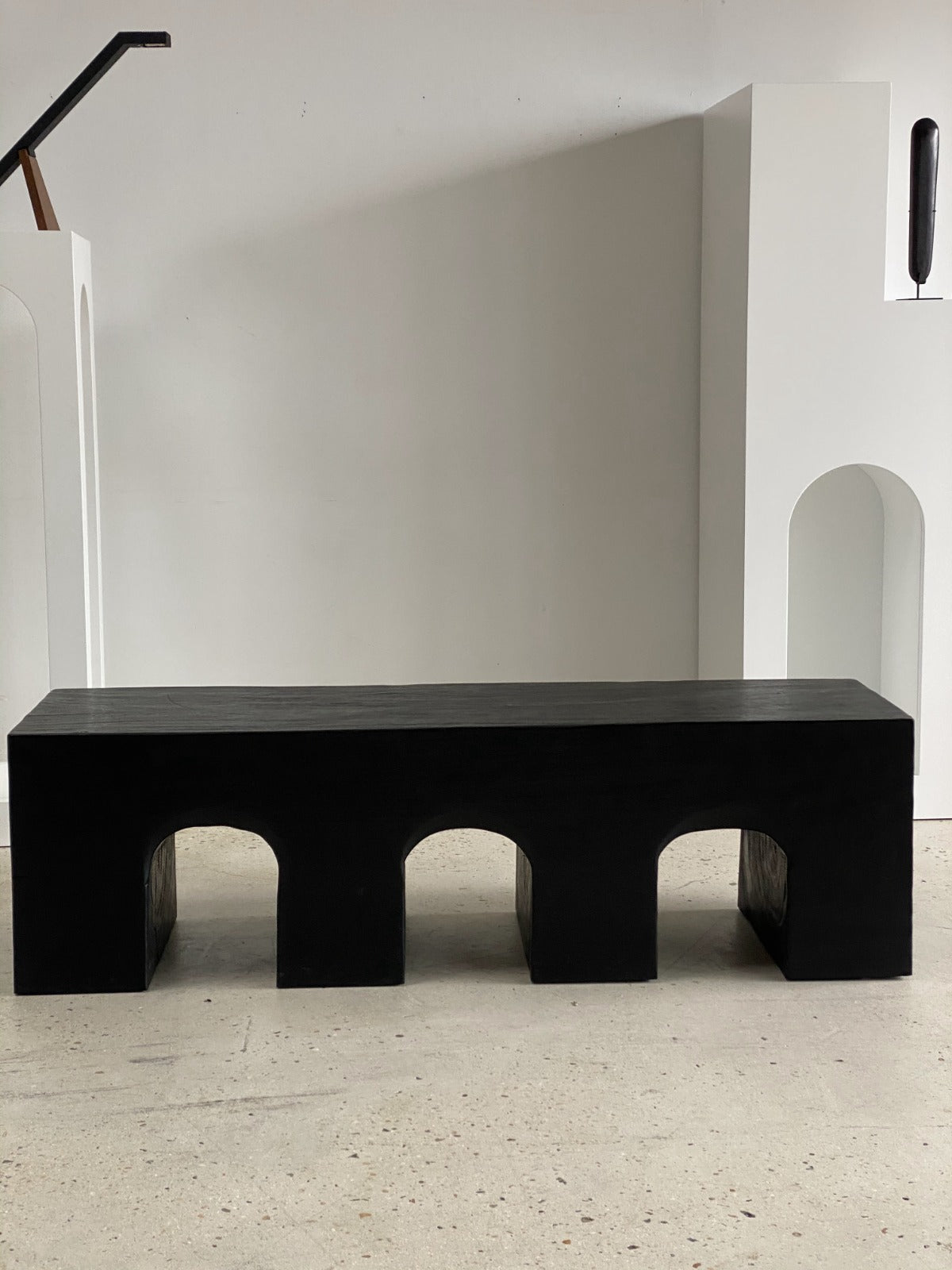 Banc en bois monoxyle massif noir piètement sculpté en 3 arches