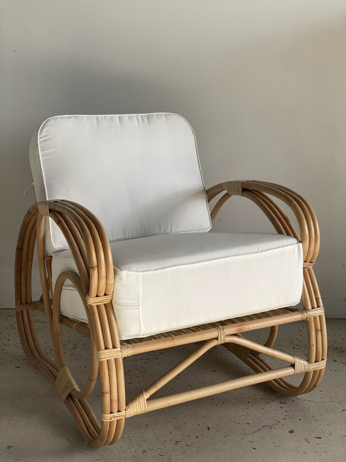 Grand fauteuil de repos en rotin et coussins blancs