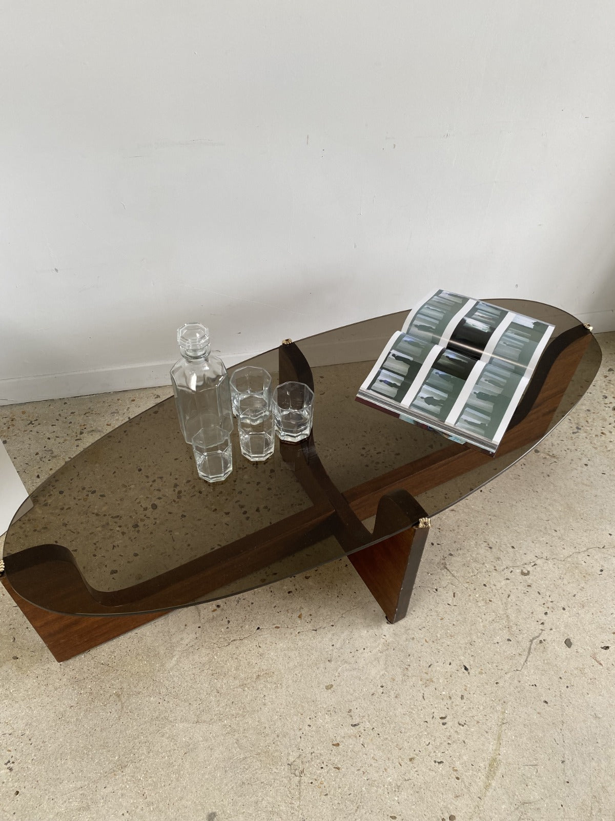 Grande table basse vintage ovale plateau de verre fumé et piètement en bois